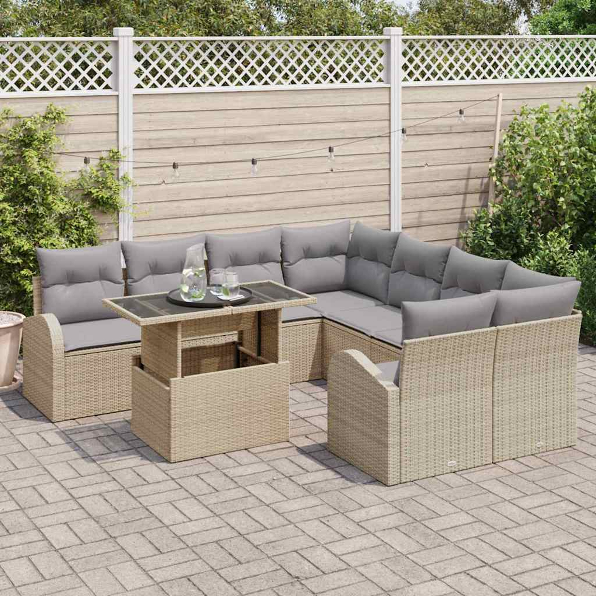 Gartenmöbel-Set aus Rattan auf einer Terrasse. Beinhaltet ein Ecksofa, einen Couchtisch und einen Zaun im Hintergrund.