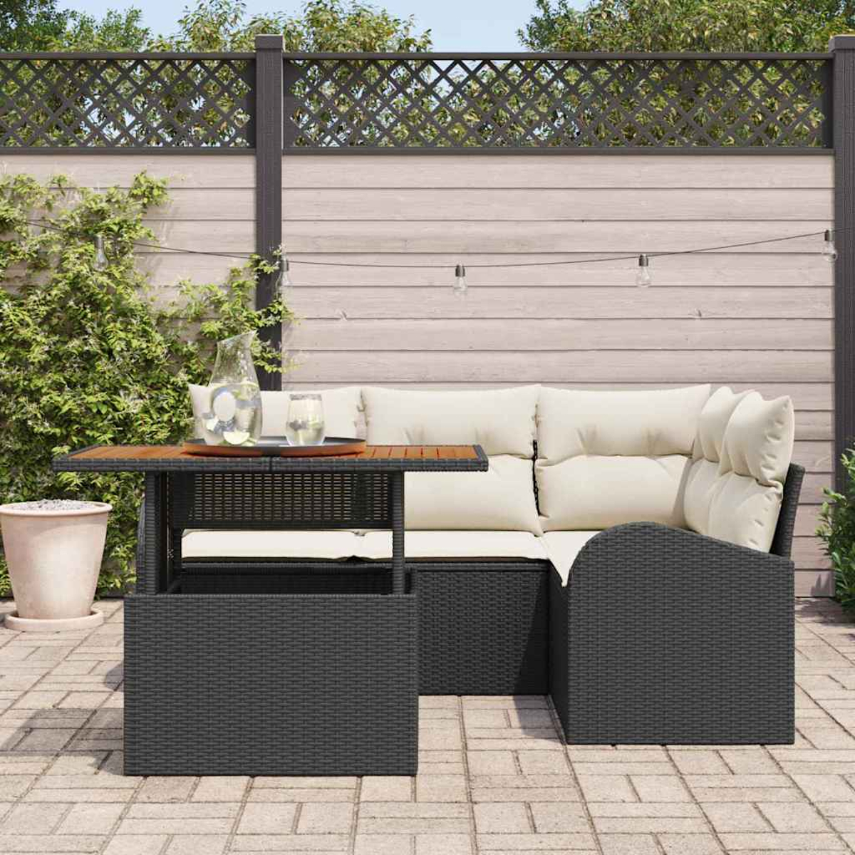 Terrassenset im Freien mit Tisch, Sofa und Gitterzaun. Auf dem Tisch stehen eine Kanne und Gläser. Grünes Laub im Hintergrund.