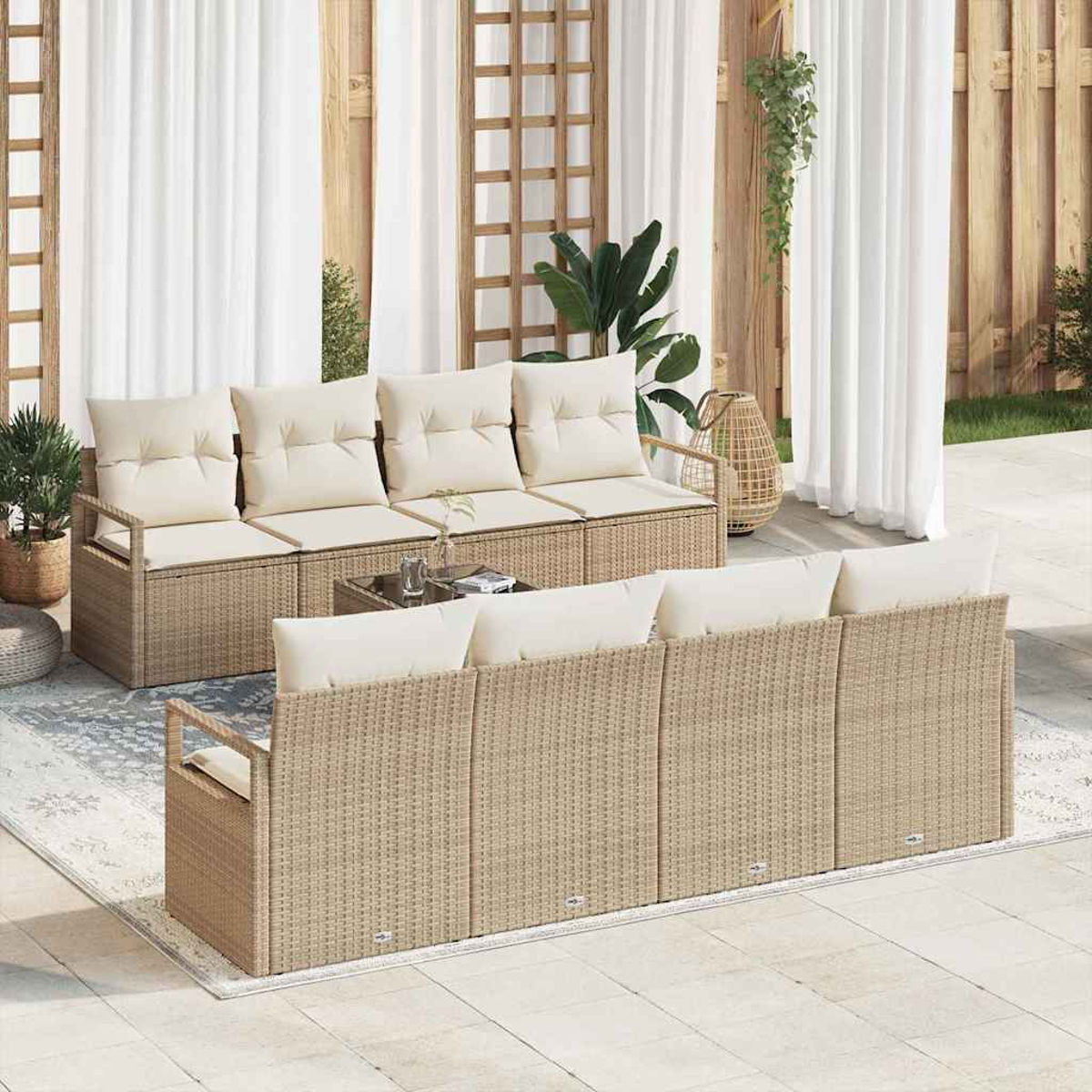 Rattan-Sofas im Freien mit cremefarbenen Kissen auf einer Terrasse. Weiße Vorhänge und Pflanzen im Hintergrund schaffen eine entspannte Atmosphäre.
