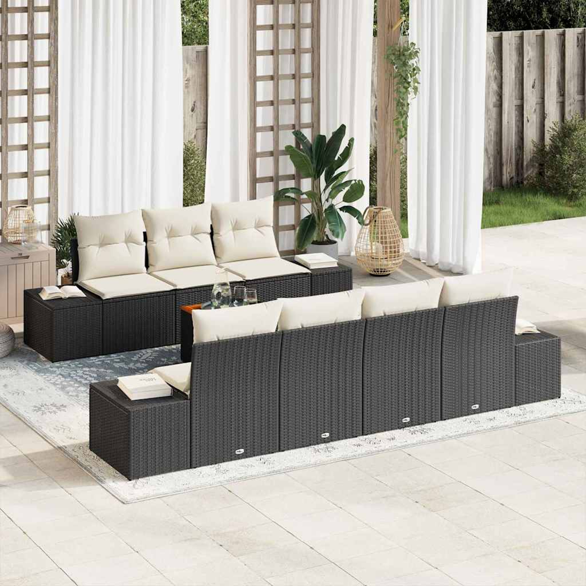 Garten-Sitzgruppe mit schwarzem Korbmöbel, cremefarbenen Kissen und weißen Vorhängen. Enthält einen Teppich, Pflanzen und dekorative Akzente.