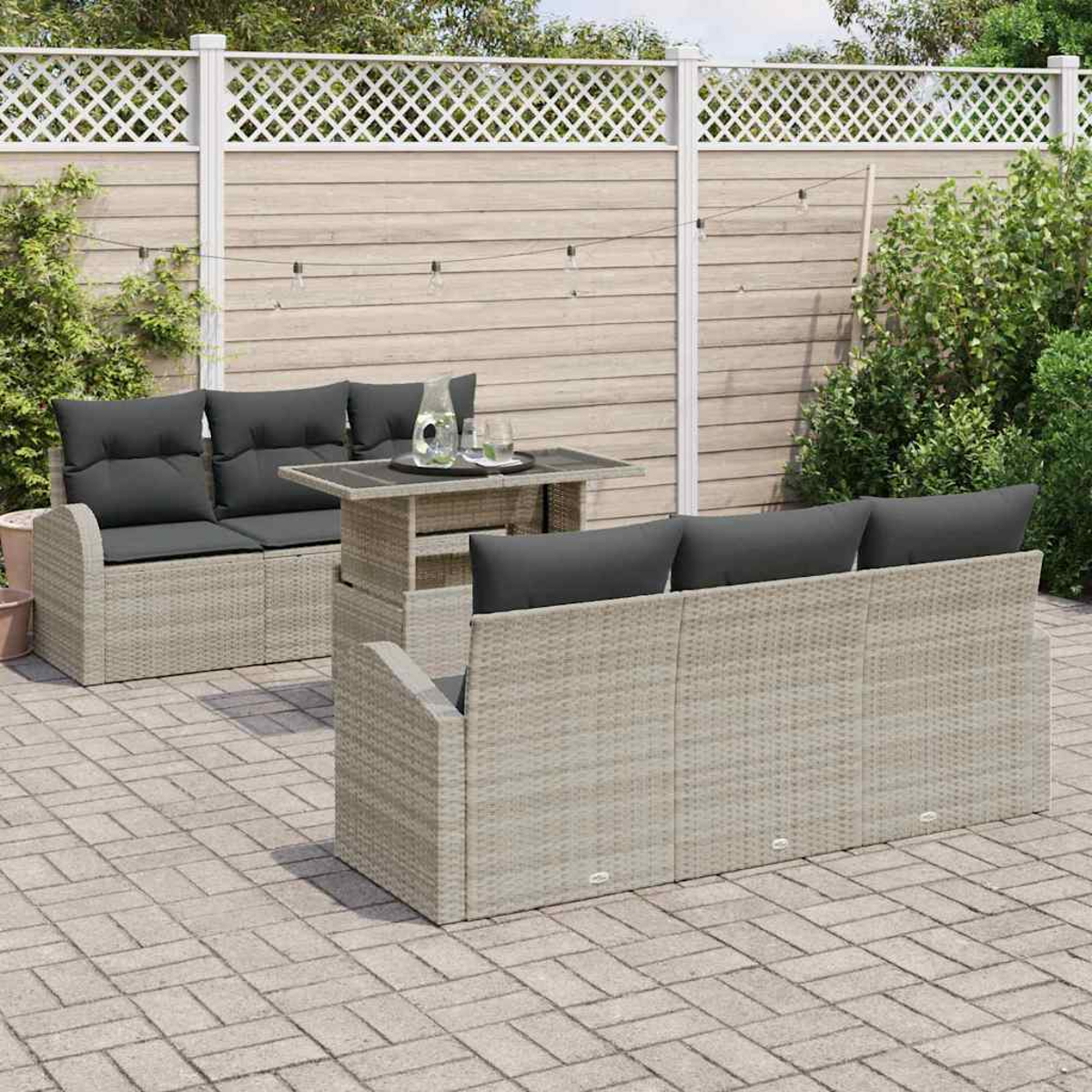 Garten-Terrassenset mit grauen Kissen und Tisch. Das Set umfasst eine Doppelsitzbank, ein Sofa und einen Tisch auf einer gepflasterten Terrasse.