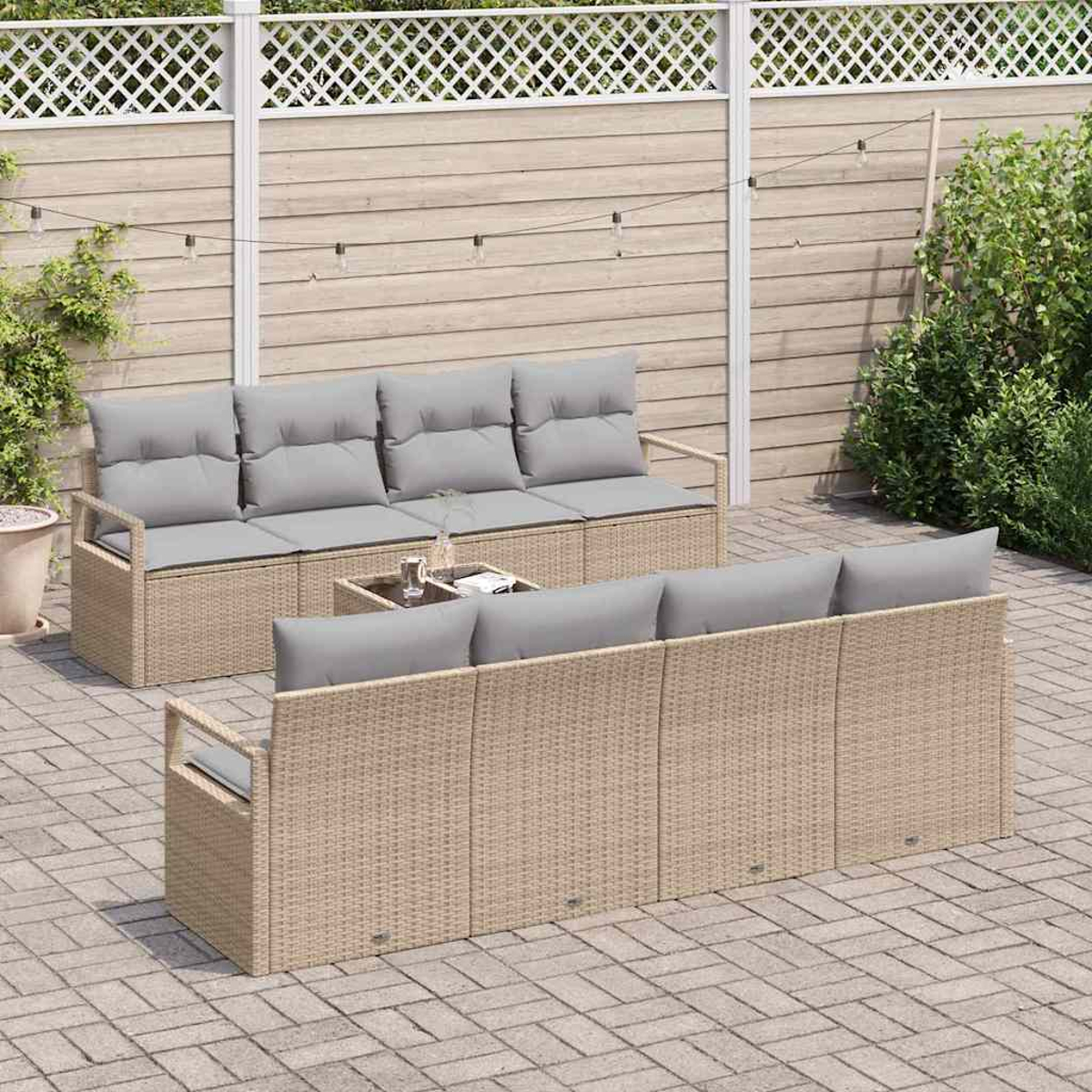 Geflecht-Gartenmöbel-Set mit grauen Kissen auf einer Backstein-Terrasse. Enthält ein Sofa, ein Zweisitzer und einen kleinen Tisch.