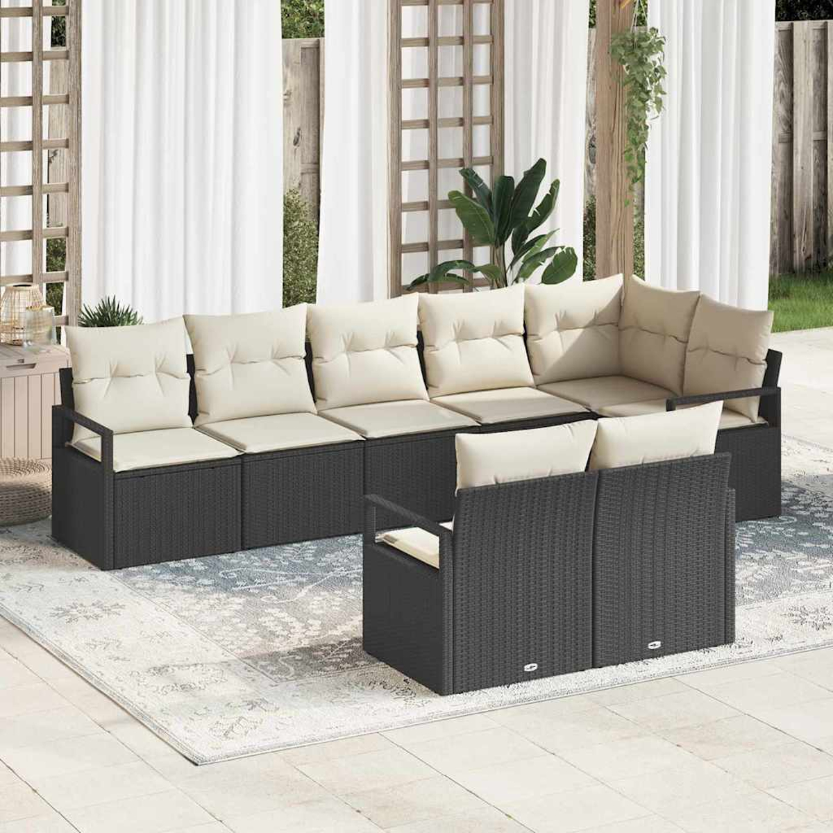 Outdoor-Ecksofa mit cremefarbenen Kissen. Es steht auf einem Teppich und einer Terrasse. Weiße Vorhänge und Pflanzen sind im Hintergrund.
