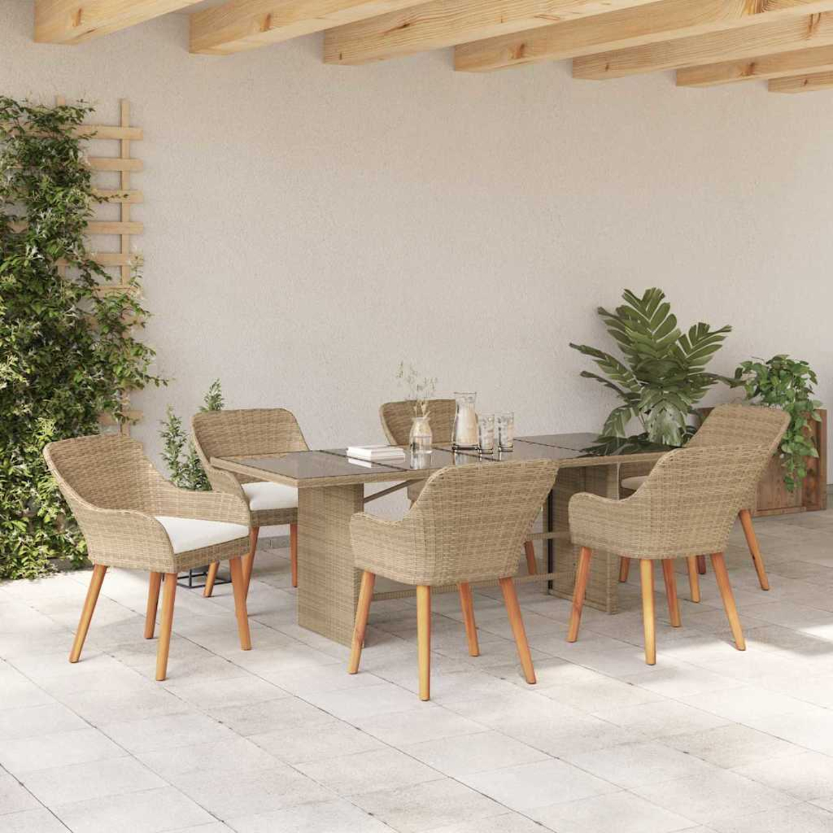 Juego de comedor al aire libre con mesa, sillas y plantas. Las sillas son de ratán con cojines blancos. La mesa tiene una tapa de cristal.