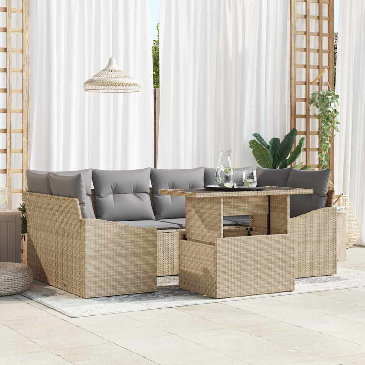 Gartenmöbel-Set aus Korbgeflecht mit grauen Kissen und einem Tisch mit Hebefunktion. Weiße Vorhänge und eine Hängelampe sind sichtbar.
