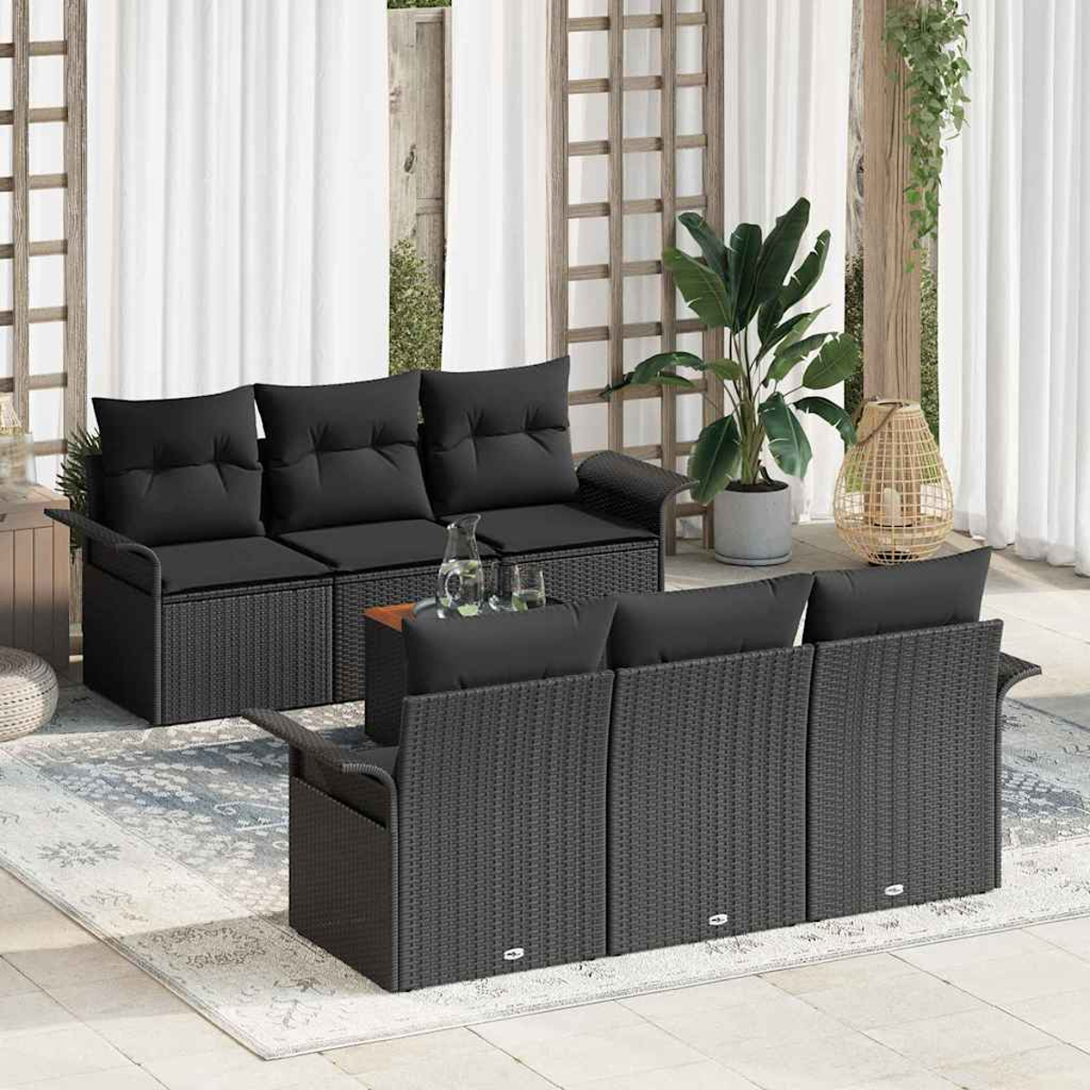 Garten-Terrassenset mit schwarzen Korbmöbeln, Kissen und einem kleinen Tisch. Enthält Pflanzen, Vorhänge und einen Teppich. Natürliches Licht.