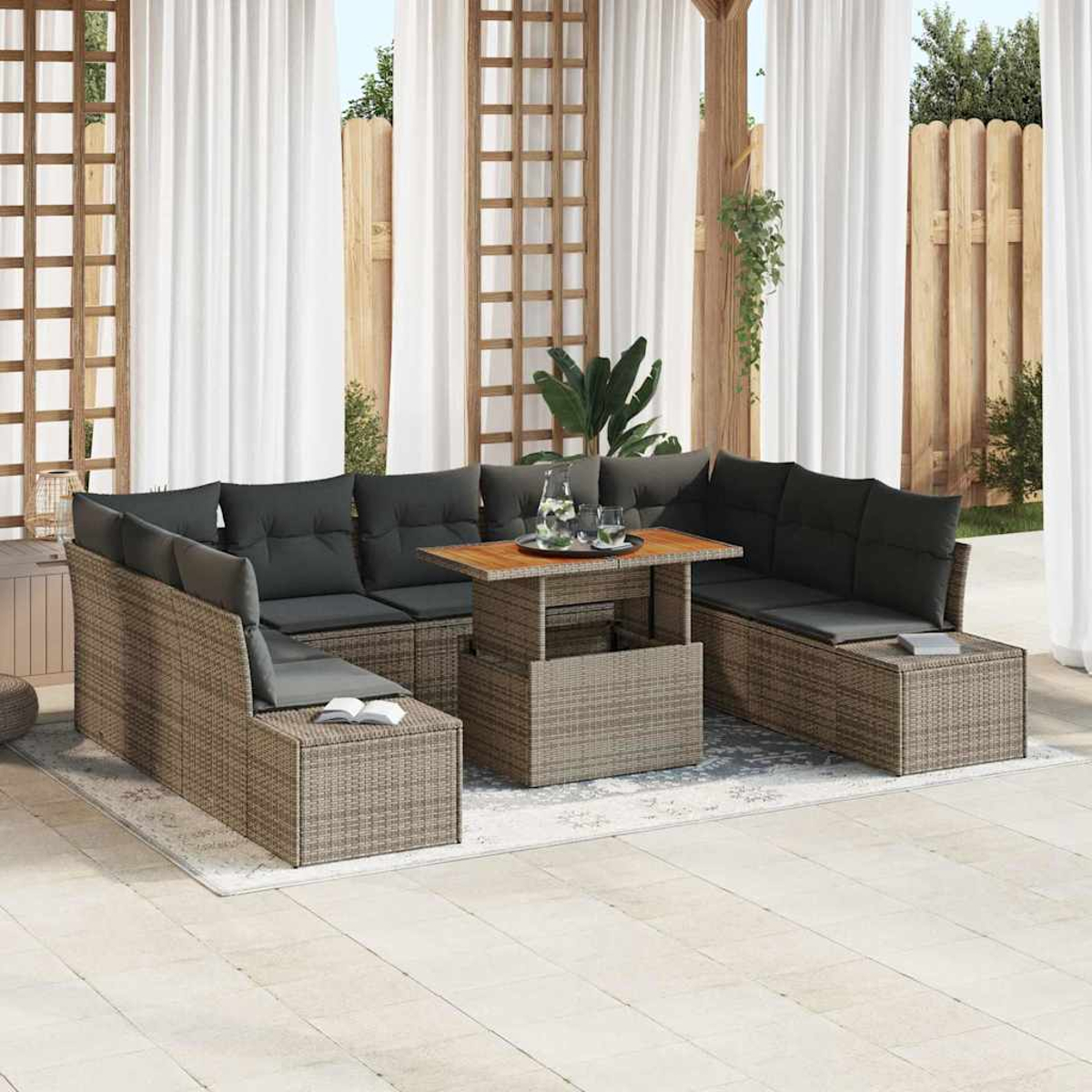 Terrassenmöbel mit grauen Kissen, einem Holztisch und weißen Vorhängen im Hintergrund. Ein Buch liegt auf einem Sitz.