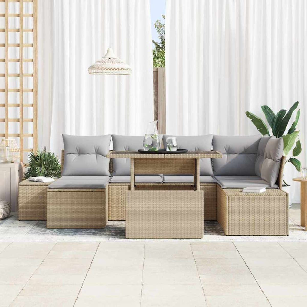Outdoor-Rattan-Möbelset mit grauen Kissen. Tisch mit Gläsern. Weiße Vorhänge und Pflanzen im Hintergrund. Beige Bodenfliesen.
