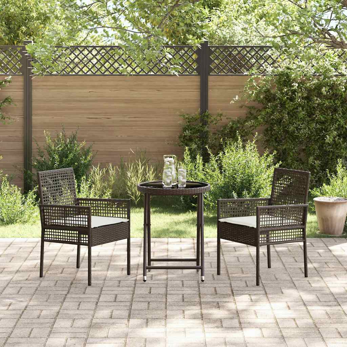 Terrassenset im Freien mit zwei Stühlen und einem kleinen Tisch. Der Hintergrund umfasst einen Holzzaun, Grün und eine Ziegelterrasse.