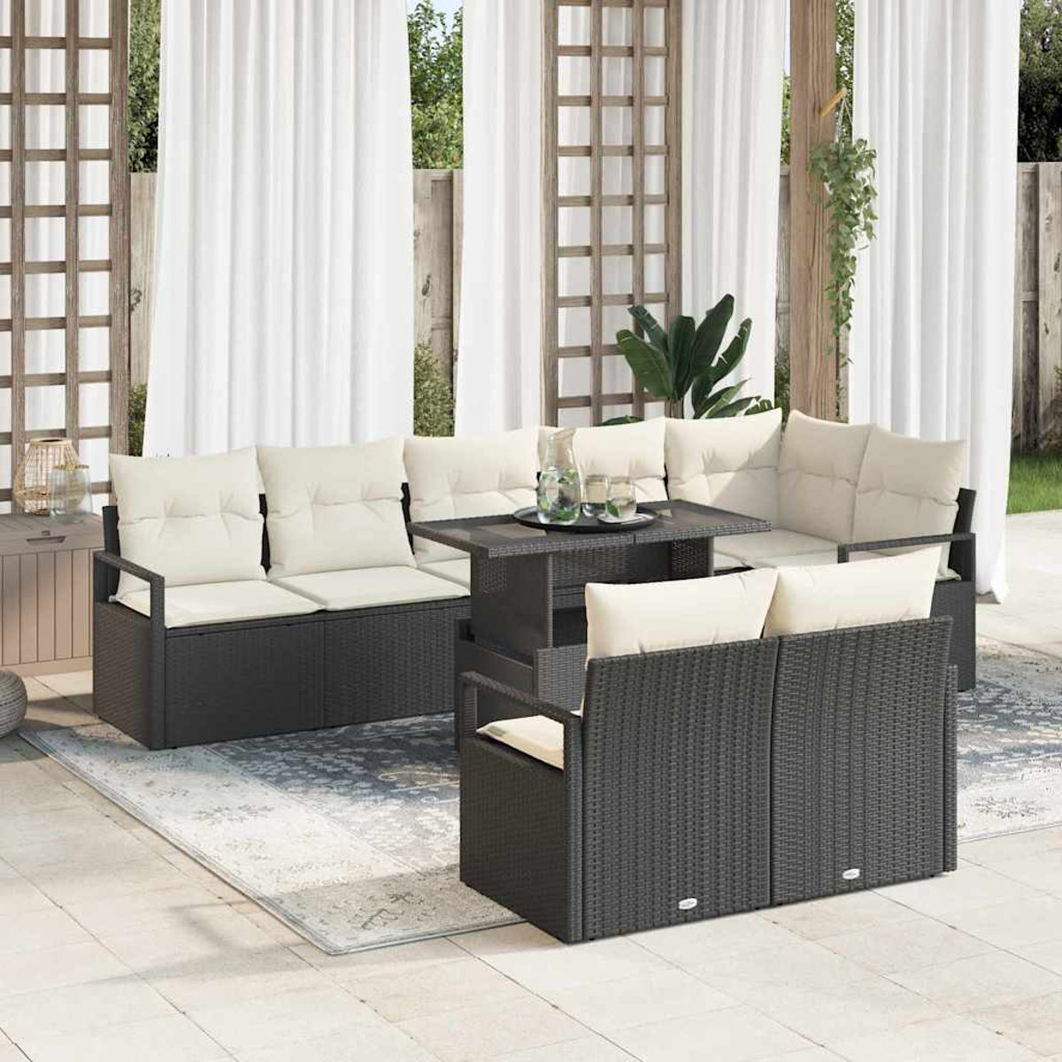 Garten-Sitzgruppe mit schwarzen Korbmöbeln und cremefarbenen Kissen, einem Tisch und weißen Vorhängen. Die Szene spielt auf einer Terrasse.