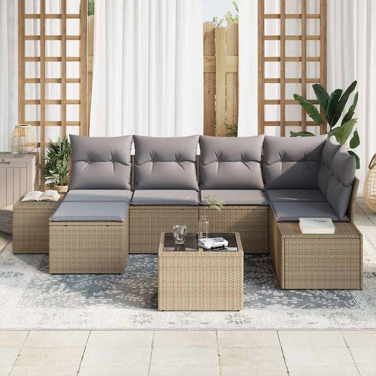 Outdoor-Ecksofa mit grauen Kissen, kleinem Glastisch und Teppich auf einer Terrasse. Im Hintergrund Vorhänge und Holzzaun.