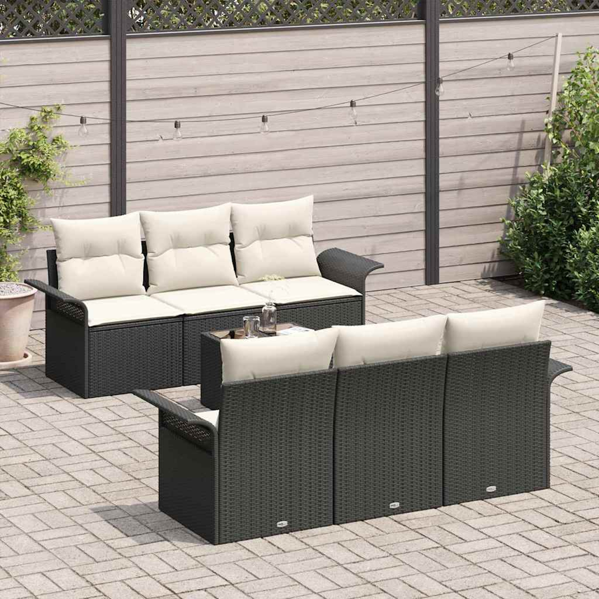 Sitzbereich im Freien mit zwei dunklen Rattan-Sofas und hellen Kissen auf einer Backsteinterrasse.