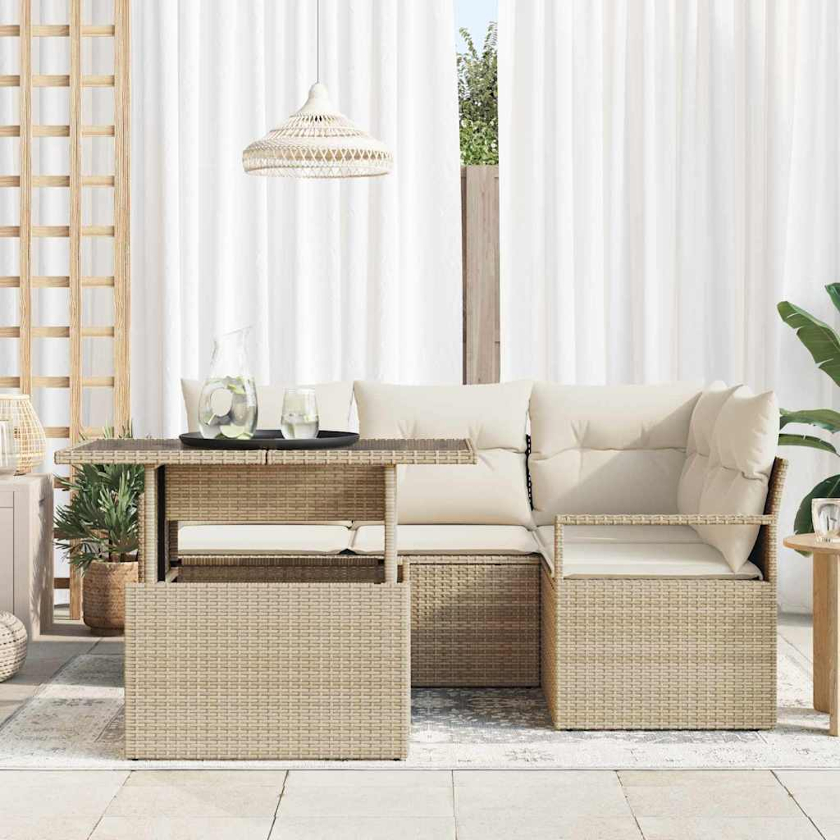 Gartenmöbel-Set aus Korbgeflecht mit Tisch, Sofa und Stühlen. Weiße Vorhänge und eine Hängelampe im Hintergrund.