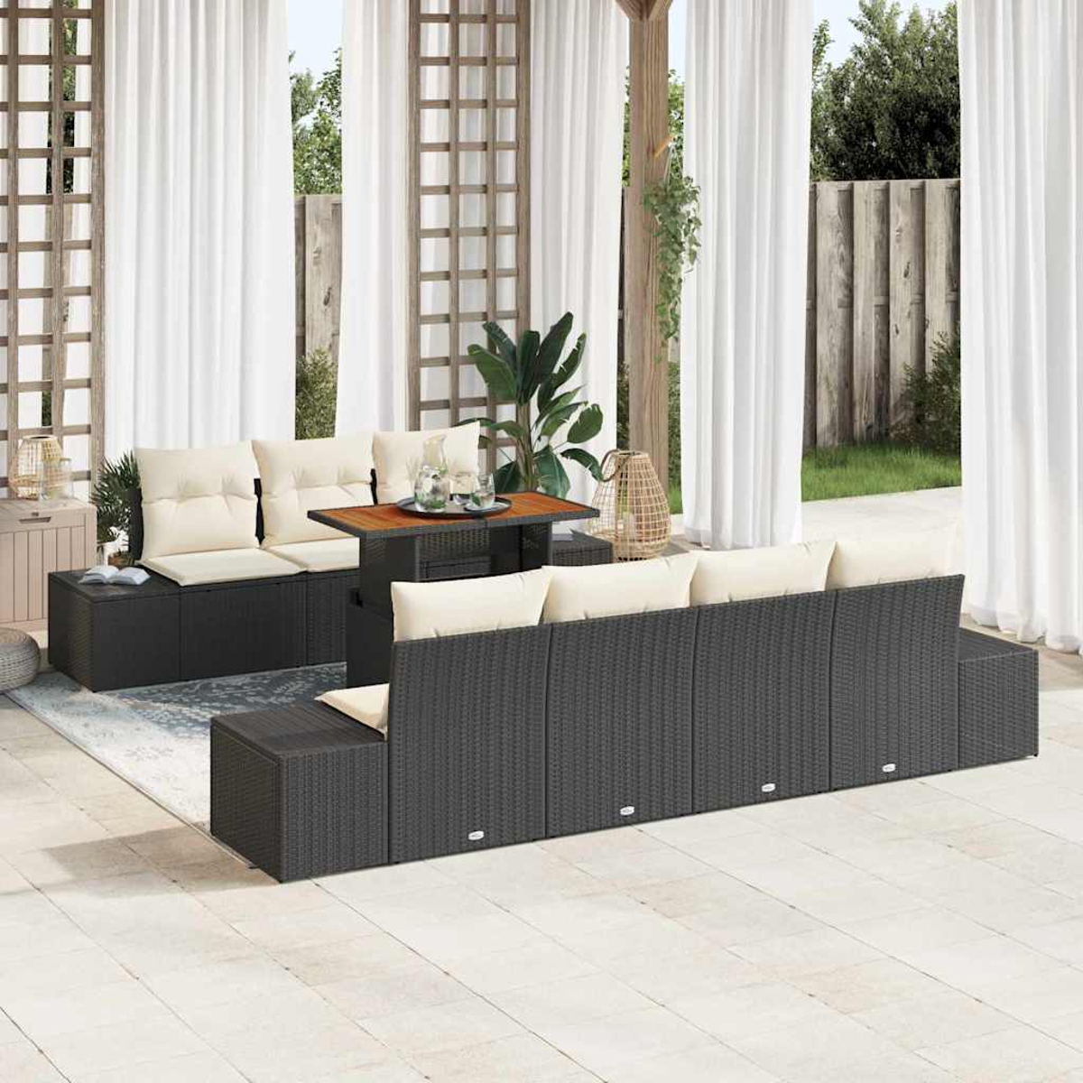 Garten-Terrassenset mit dunkelgrauen Korbmöbeln, cremefarbenen Kissen und einem Holztisch vor weißen Vorhängen.