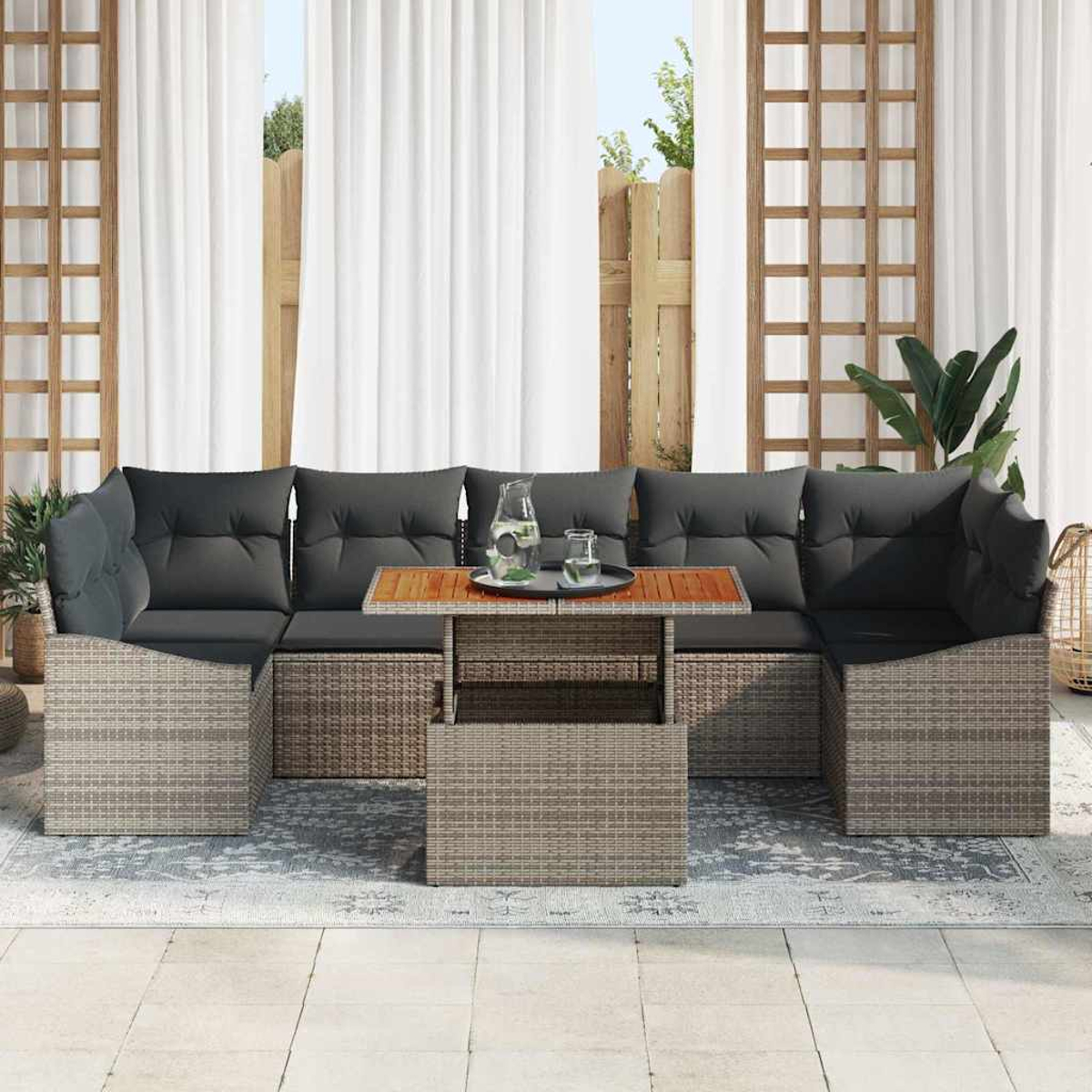 Ein Outdoor-Terrassenset mit grauen Kissen, einem Holztisch mit Tablett und einem Hintergrund aus Vorhängen und einem Holzzaun.