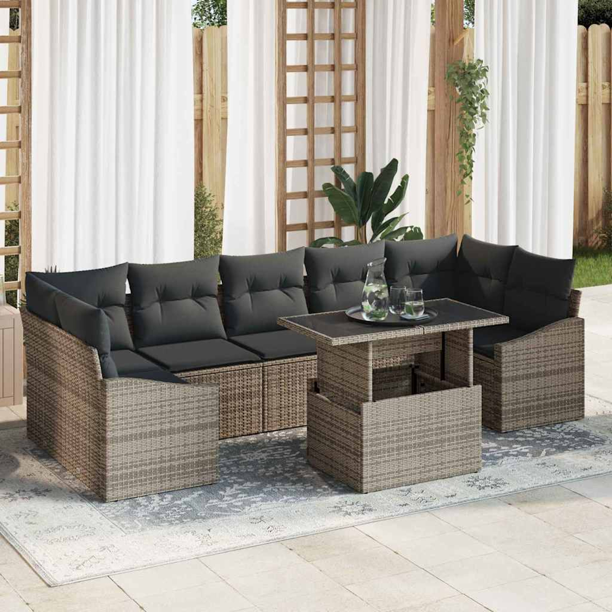 Garten-Sitzgruppe mit grauen Kissen und einem Tisch mit Hubfunktion. Weiße Vorhänge und Holzgitter im Hintergrund.