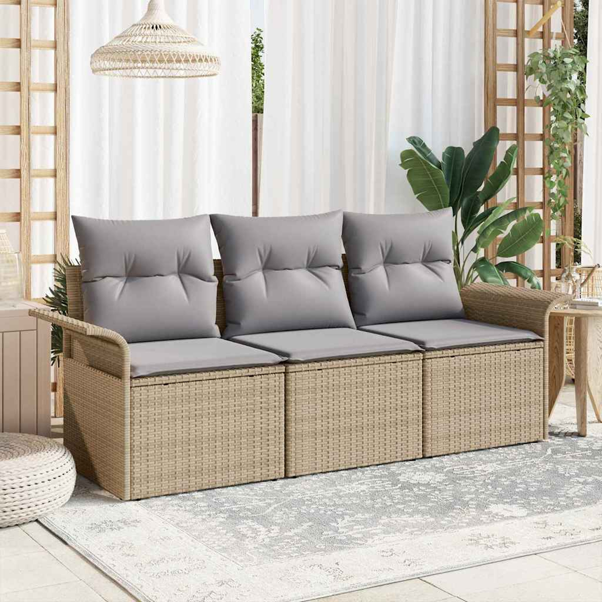 Geflochtenes Sofa mit grauen Kissen auf einer Terrasse. Ein Teppich und Pflanzen sind vorhanden. Eine Hängelampe und ein Spalier sind sichtbar.