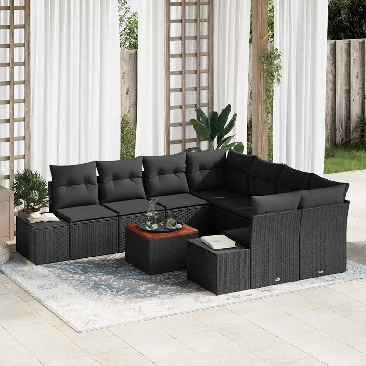 Outdoor-Ecksofa mit schwarzen Kissen, einem Couchtisch und Beistelltischen. Weiße Vorhänge und Holzgitter im Hintergrund.