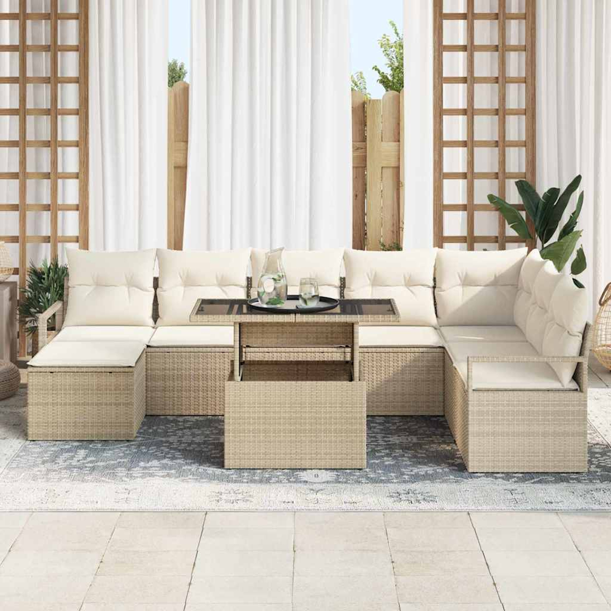 Outdoor-Ecksofa mit beigen Kissen und gewebter Basis. Ein Tisch mit Getränken steht in der Mitte. Weiße Vorhänge im Hintergrund.