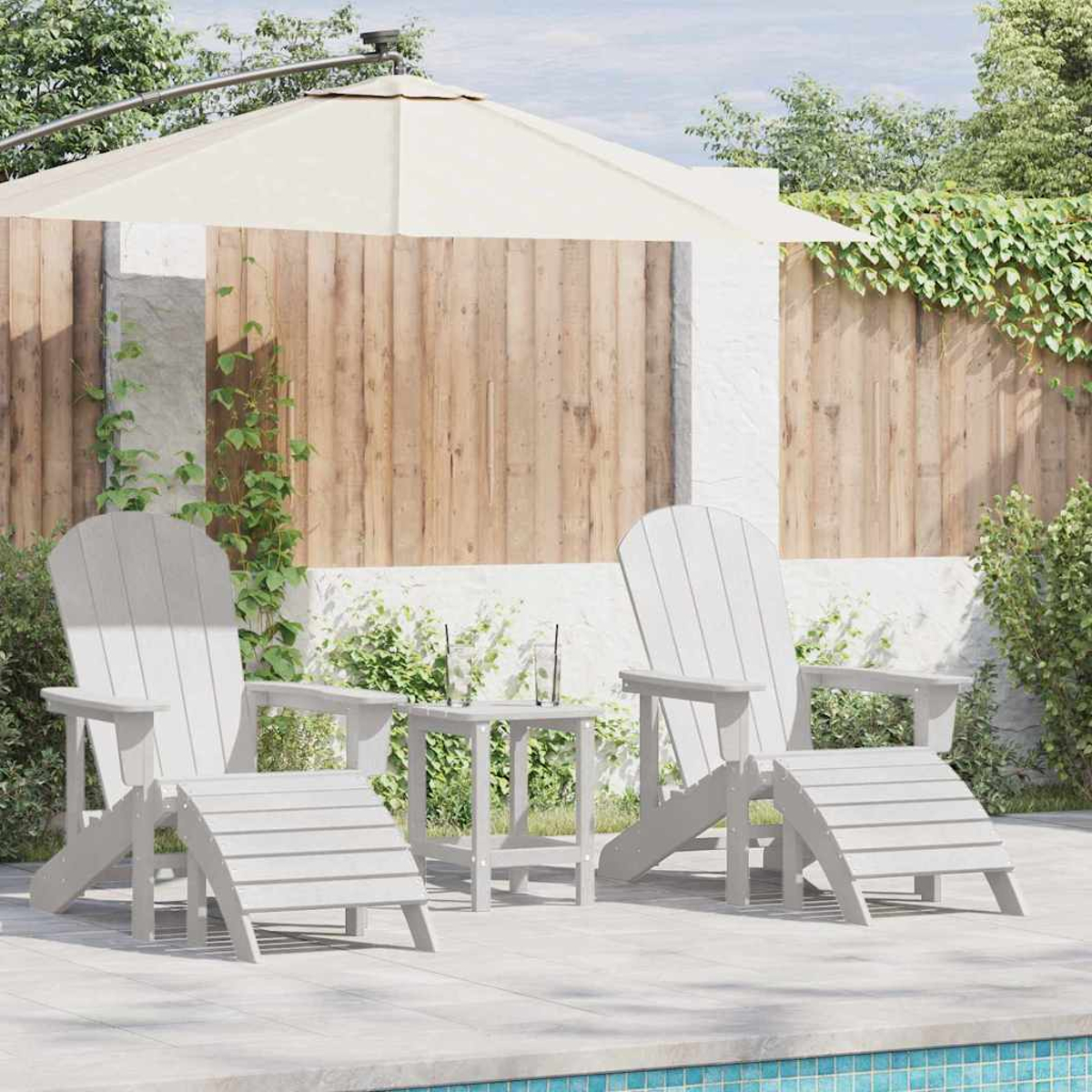 Zwei weiße Adirondack-Stühle mit Fußstützen, ein kleiner Tisch und ein großer Sonnenschirm auf einer Terrasse.