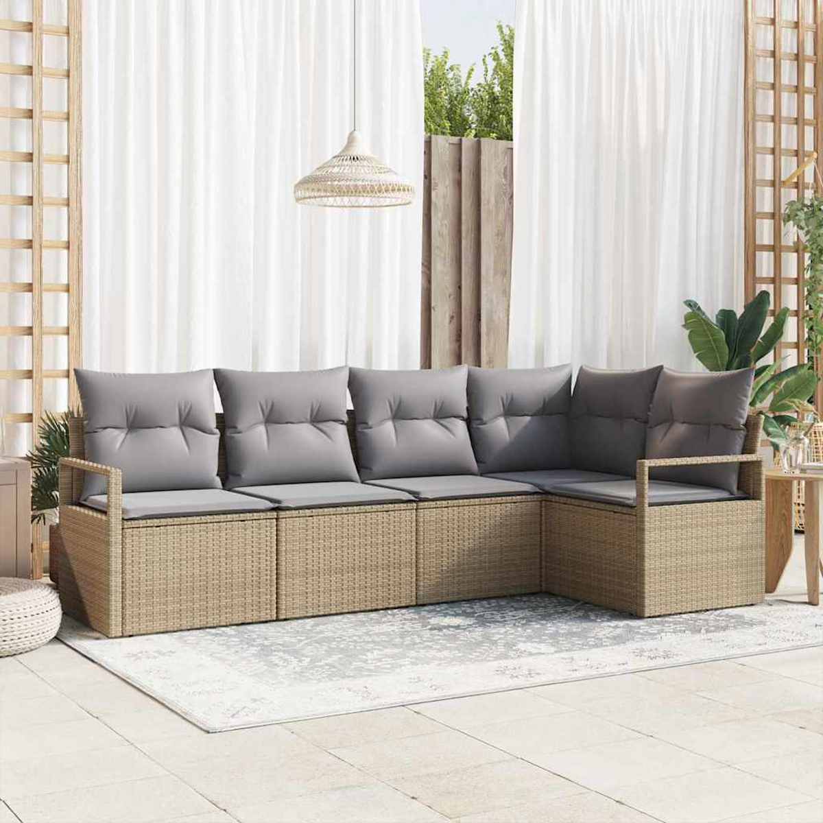 Ecksofa für den Außenbereich mit grauen Kissen. Beiger Korbrahmen. Weiße Vorhänge im Hintergrund. Teppich auf dem Boden. Dekorative Pendelleuchte.