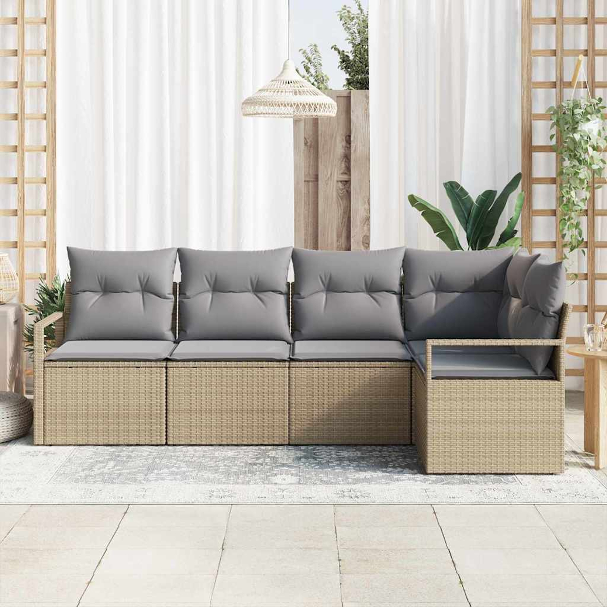 Outdoor-Rattansofa mit grauen Kissen. Im Hintergrund Vorhänge, Pflanzen und eine Hängelampe für eine entspannte Szene.
