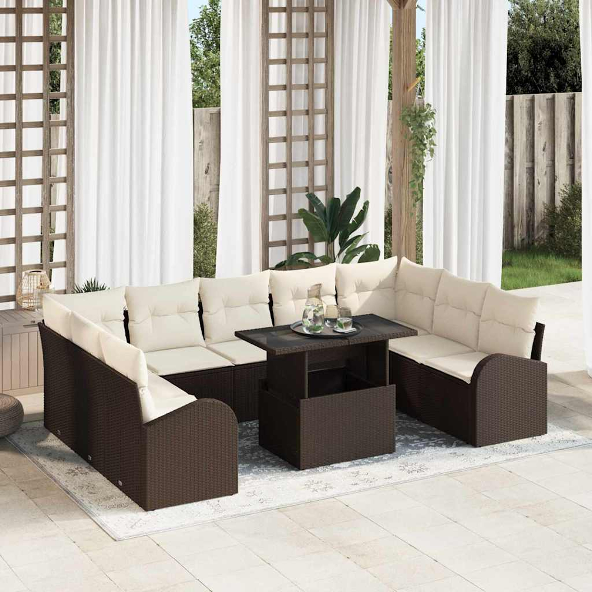 Ein Outdoor-Terrassenset. Es hat braune Korbmöbel mit cremefarbenen Kissen, einen Tisch mit Getränken und weiße Vorhänge im Hintergrund.