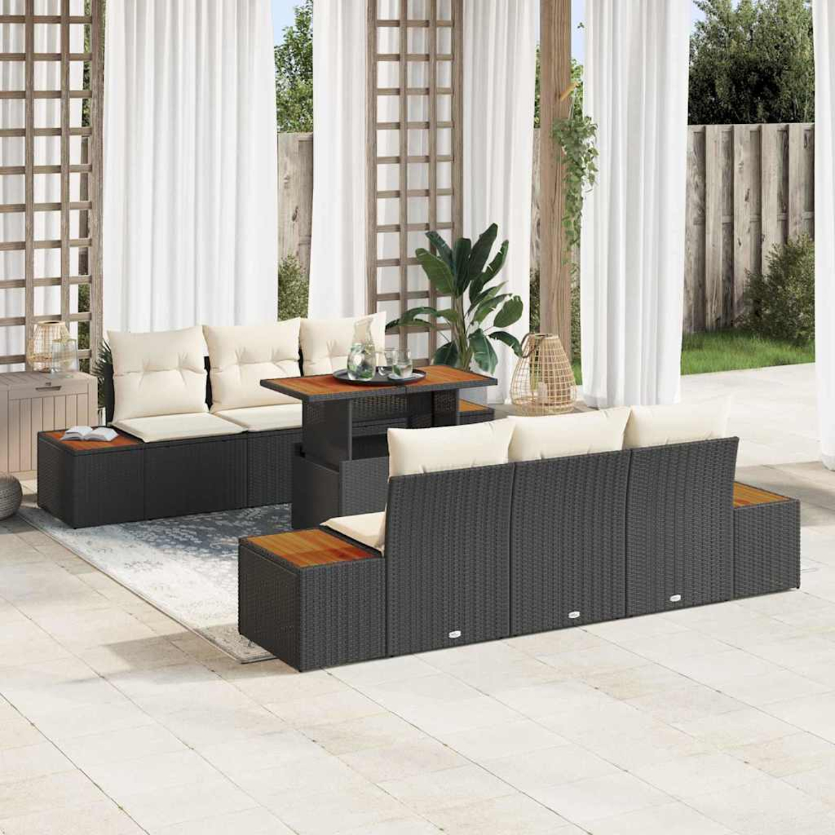 Gartenmöbel-Set mit schwarzem Korbgeflecht und beigen Kissen. Enthält einen Tisch und Sitzgelegenheiten. Weiße Vorhänge und ein Holzzaun im Hintergrund.