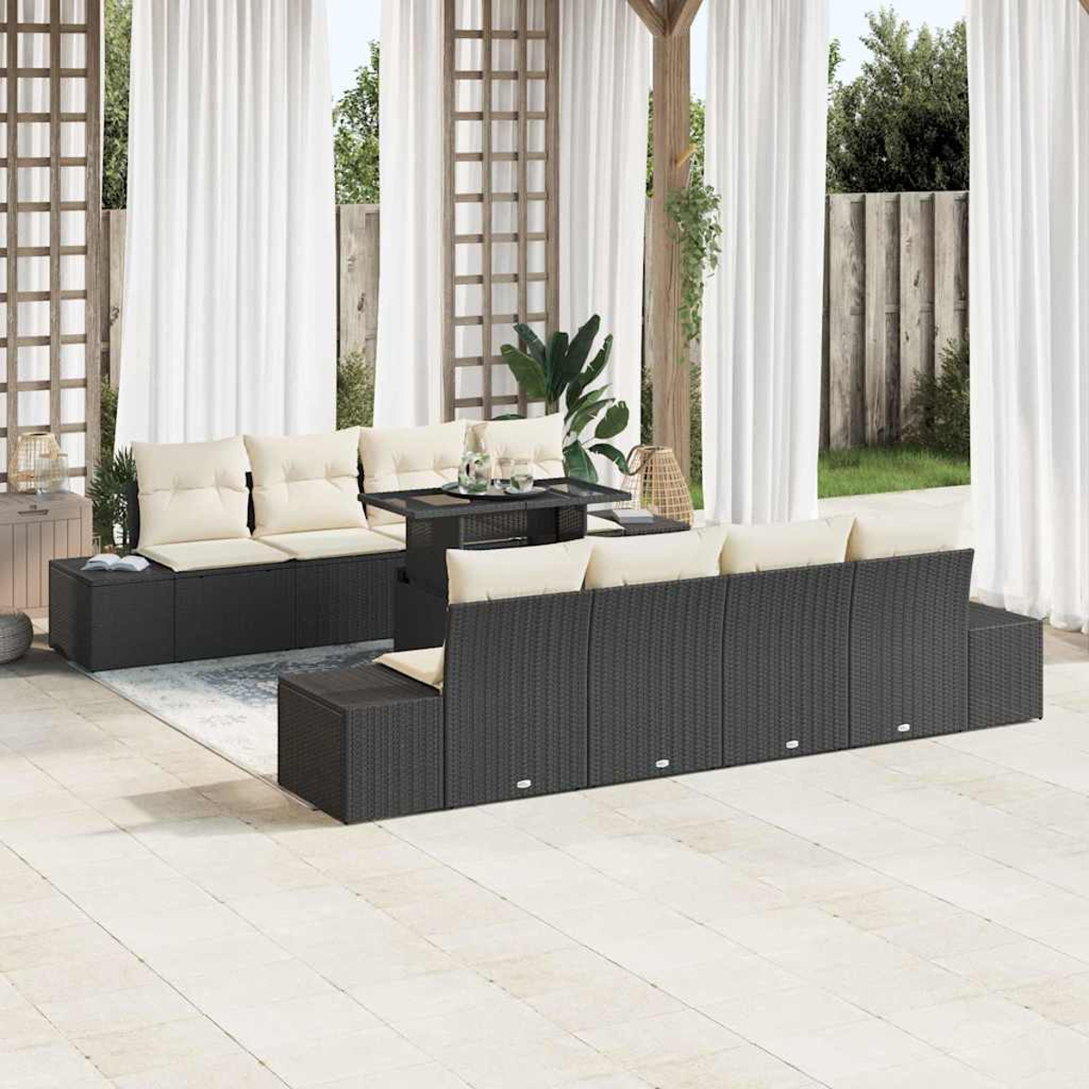 Juego de muebles de patio: sofás de mimbre negro con cojines crema, una mesa y cortinas blancas al fondo.
