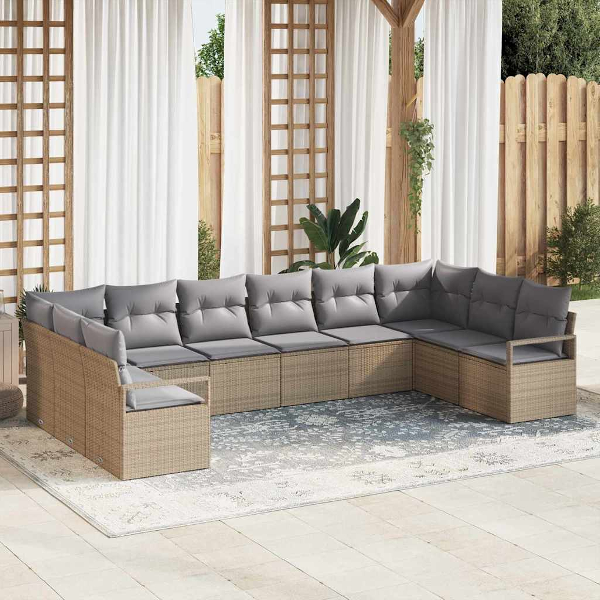 Outdoor-Ecksofa mit grauen Kissen auf einem gemusterten Teppich. Weiße Vorhänge, Holzgitter und Zaun im Hintergrund.