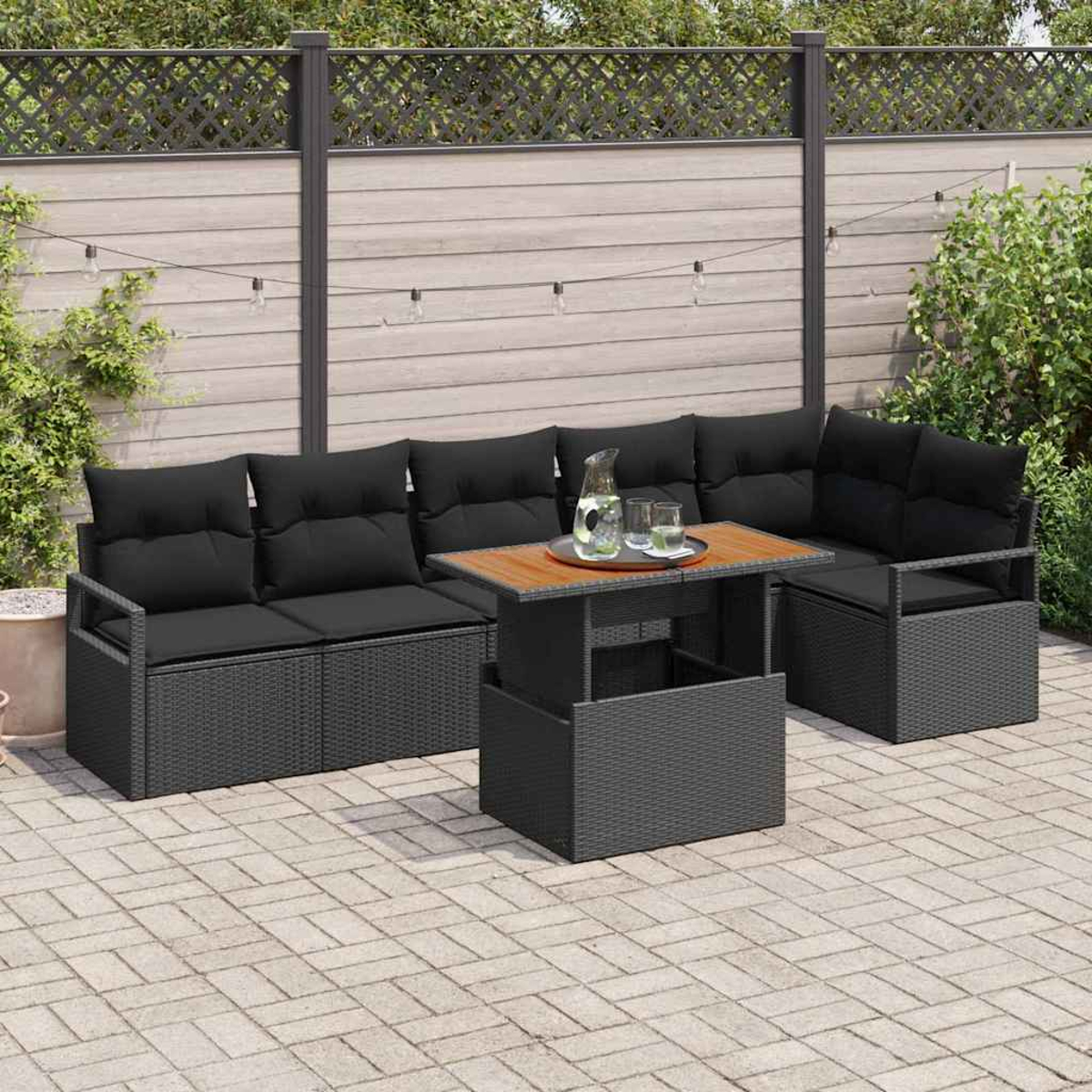 Gartenmöbel-Set mit schwarzen Kissen, Tisch mit Getränken und Holzzaun im Hintergrund.