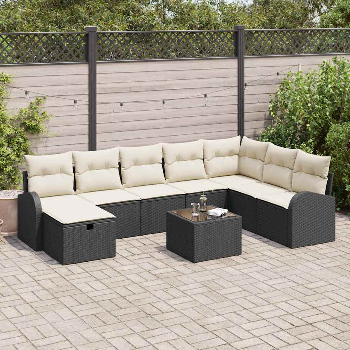 Outdoor-Ecksofa mit cremefarbenen Kissen und dunkelgrauem Rahmen. Ein kleiner Tisch mit Gläsern und einem Buch. Im Hintergrund ein Zaun.
