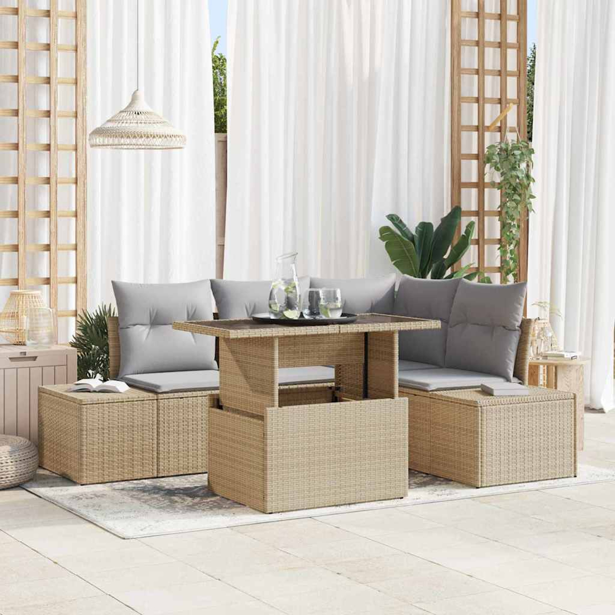 Gartenmöbel-Set mit Tisch, zwei Sofas und Kissen. Weiße Vorhänge und Pflanzen im Hintergrund.
