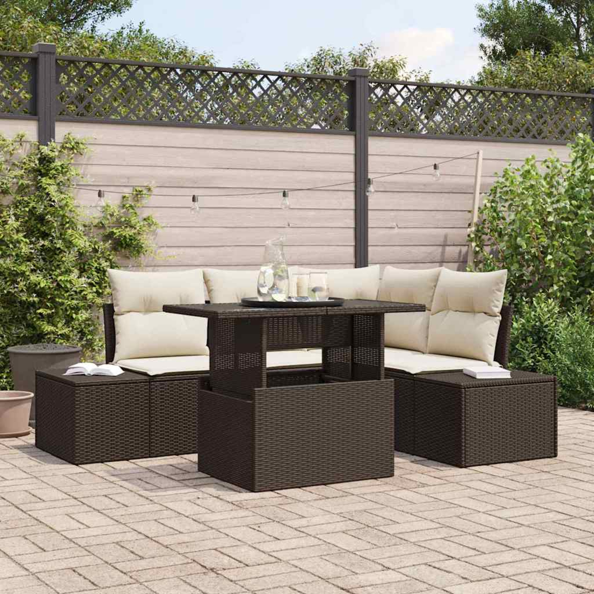 Gartenmöbel-Set. Dunkelbraunes Korbmöbel-Set mit beigen Kissen. Ziegel-Patio mit Holzzaun im Hintergrund.
