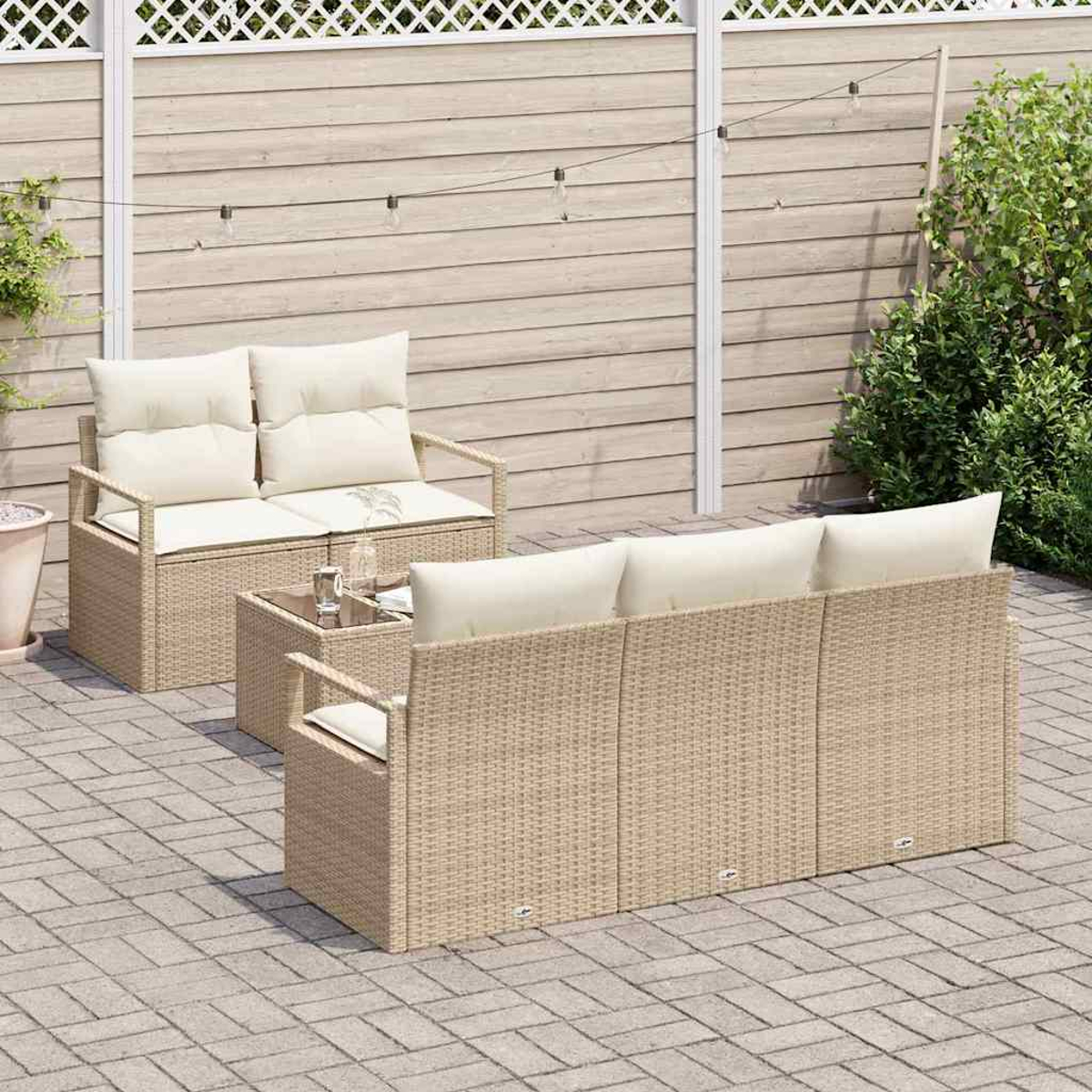 Gartenmöbel-Set aus Korbgeflecht mit cremefarbenen Kissen. Besteht aus einem Zweisitzer, einem Sofa und einem Couchtisch.