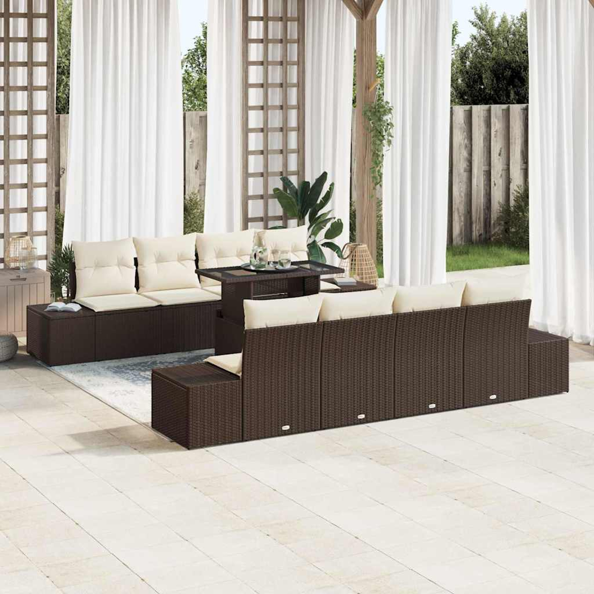 Outdoor-Sitzgruppe mit braunen Korbs Sofas, beigen Kissen und einem kleinen Tisch. Weiße Vorhänge und eine Holzkonstruktion im Hintergrund.