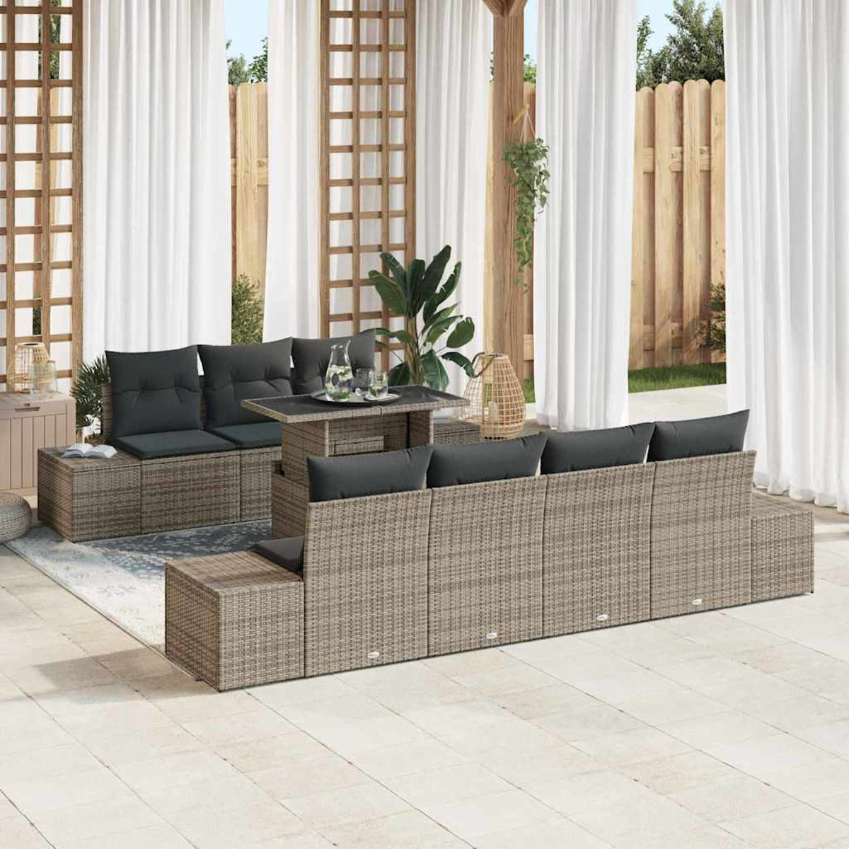 Garten-Terrassenset mit grauen Kissen und einem Tisch. Weiße Vorhänge, Holzzaun und Pflanzen schaffen ein entspanntes Ambiente.