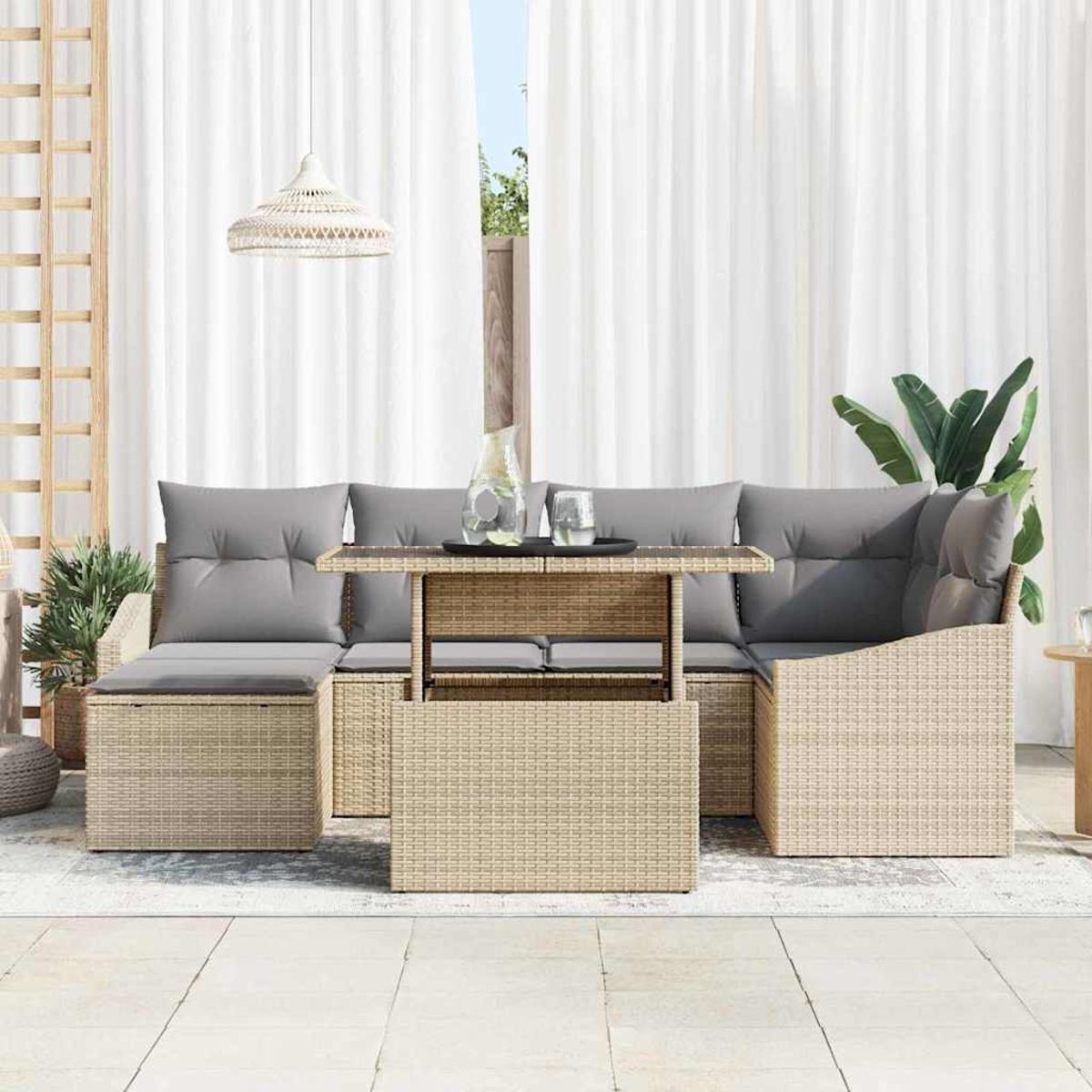 Gartenmöbel-Set aus Korbgeflecht mit grauen Kissen, Tisch und Pflanzen, vor weißen Vorhängen und hellem Himmel.
