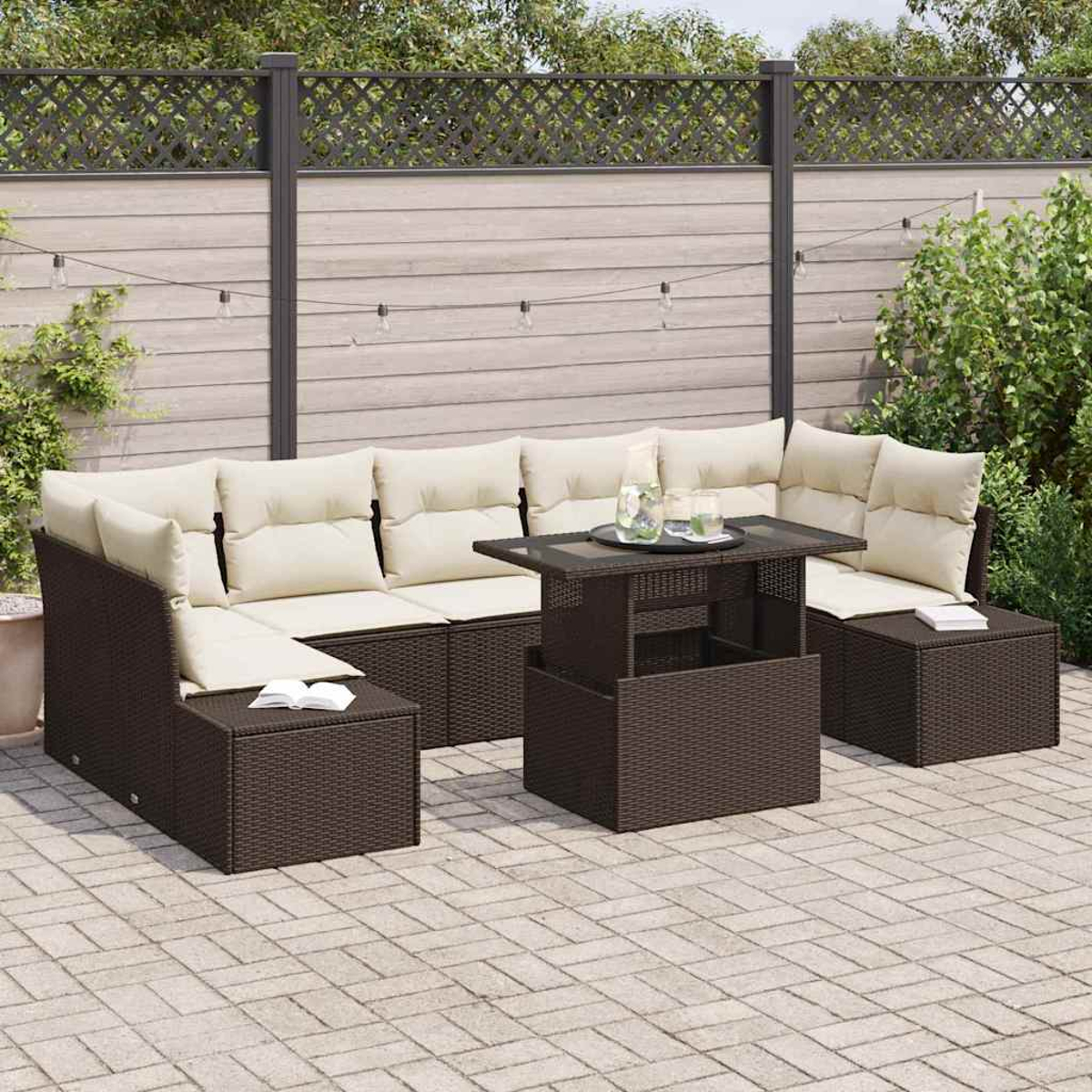 Garten-Sitzgruppe mit beigen Kissen und einem dunkelbraunen Tisch auf einer gepflasterten Terrasse. Im Hintergrund ist ein Holzzaun.