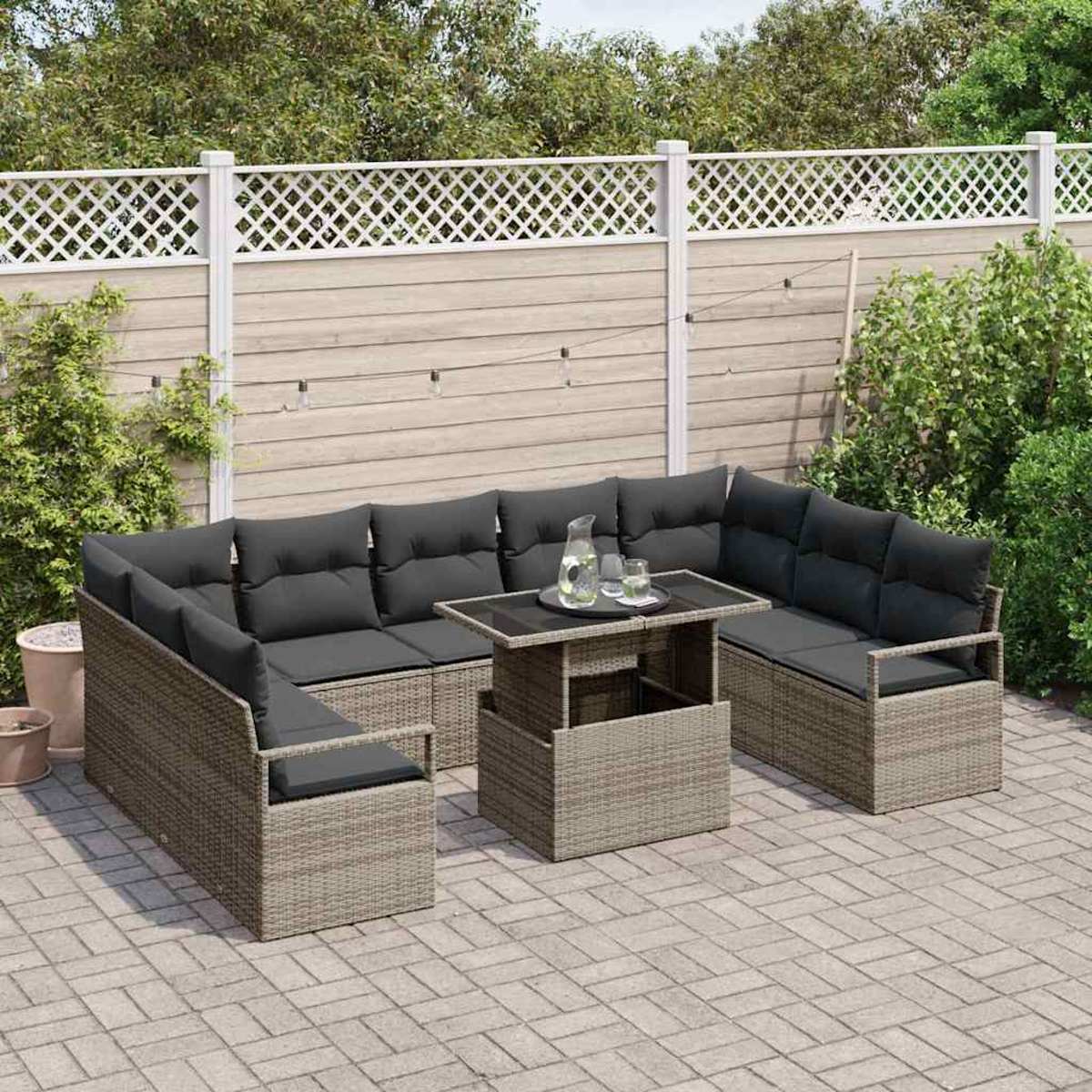 Outdoor-Ecksofa mit grauen Kissen, einem Tisch mit Gläsern und einem weißen Zaun im Hintergrund, auf einer Backstein-Terrasse.