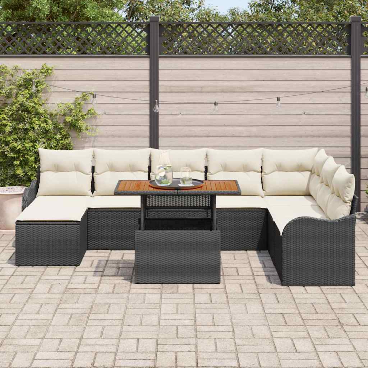 Outdoor-Ecksofa mit cremefarbenen Kissen und einem kleinen Tisch. Der Hintergrund umfasst einen Holzzaun und Pflanzen.