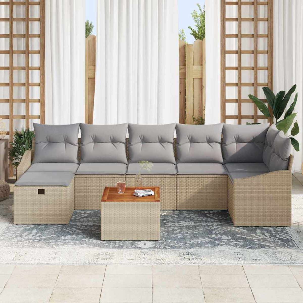 Outdoor-Ecksofa mit grauen Kissen, kleinem Holztisch und gemustertem Teppich. Weiße Vorhänge im Hintergrund.