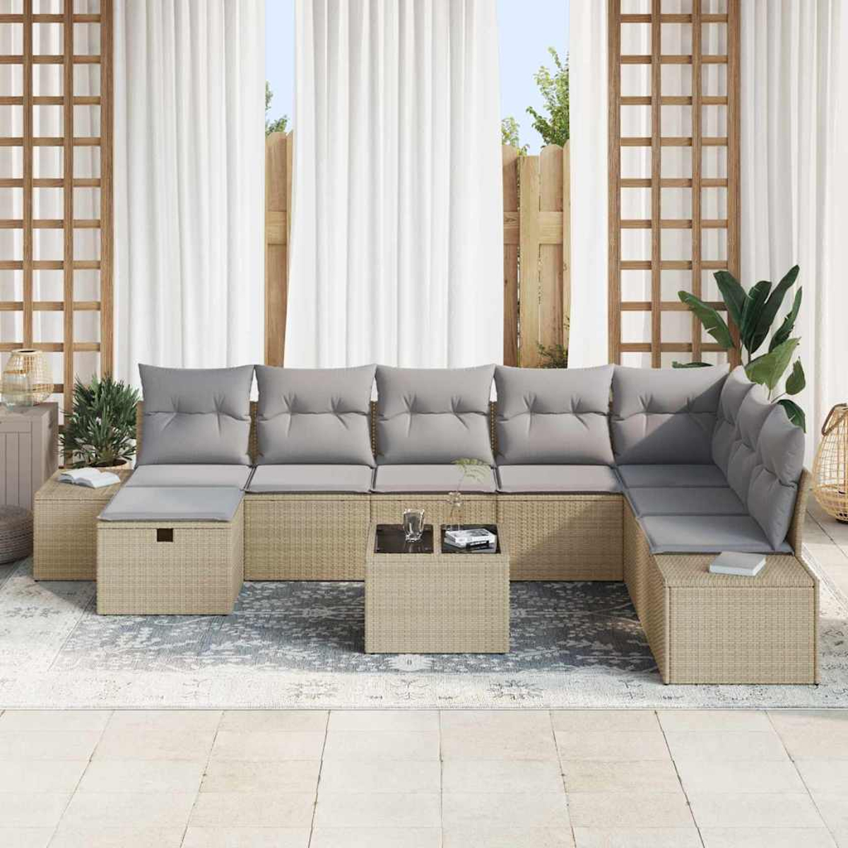 Beige Korbsessel mit grauen Kissen. Ein kleiner Tisch mit Gläsern und Büchern. Weiße Vorhänge und Holzgitter im Hintergrund.