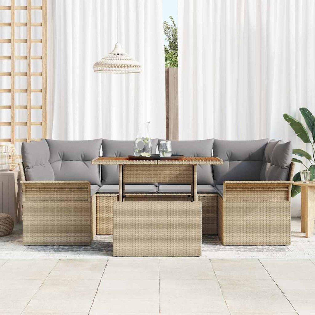 Gartenmöbel-Set aus Korb: Sofa mit grauen Kissen, Tisch mit Hubfunktion und zwei Sesseln auf einer Terrasse mit Vorhängen.