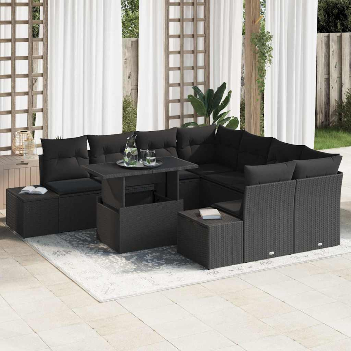 Schwarzes Outdoor-Sofa aus Korbgeflecht mit Kissen, einem Tisch mit Hubfunktion und einem Teppich. Weiße Vorhänge und ein Holzgitter im Hintergrund.