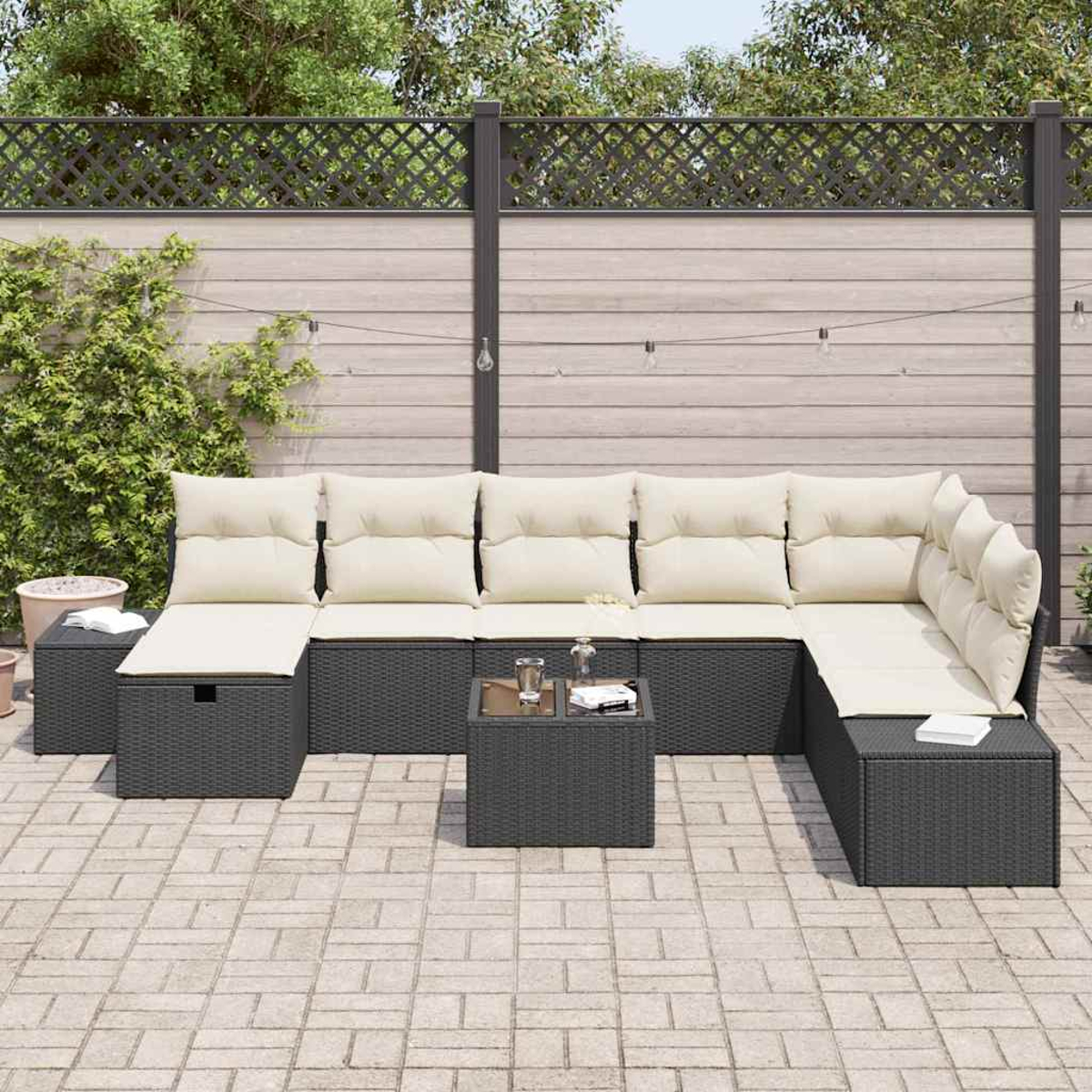 Outdoor-Ecksofa mit beigen Kissen und einem kleinen Tisch. Es steht auf einer Backstein-Terrasse mit Holzzaun im Hintergrund.