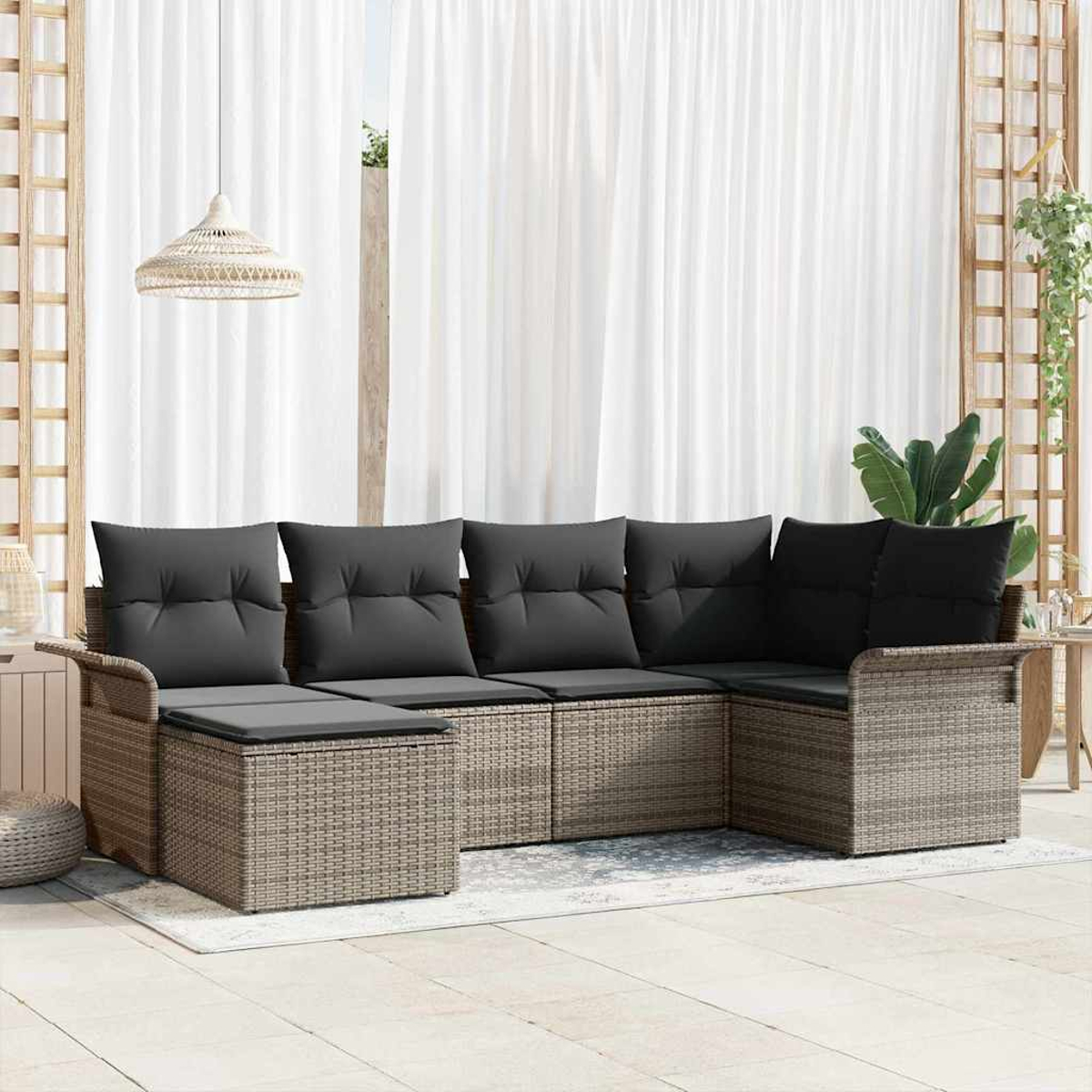 Gartensofa mit grauen Kissen. Weiße Vorhänge im Hintergrund. Eine Hängelampe und Pflanzen.