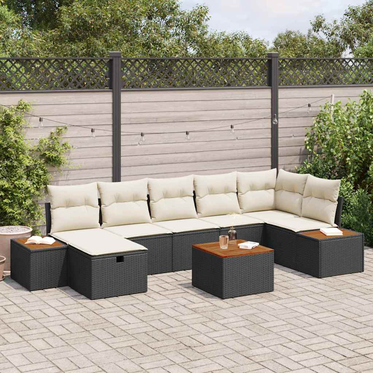 Outdoor-Ecksofa mit beigefarbenen Kissen und dunkelgrauem Korbgeflecht. Zwei kleine Tische und eine Aufbewahrungs-Ottomane. Auf einer Terrasse, Hintergrundzaun.