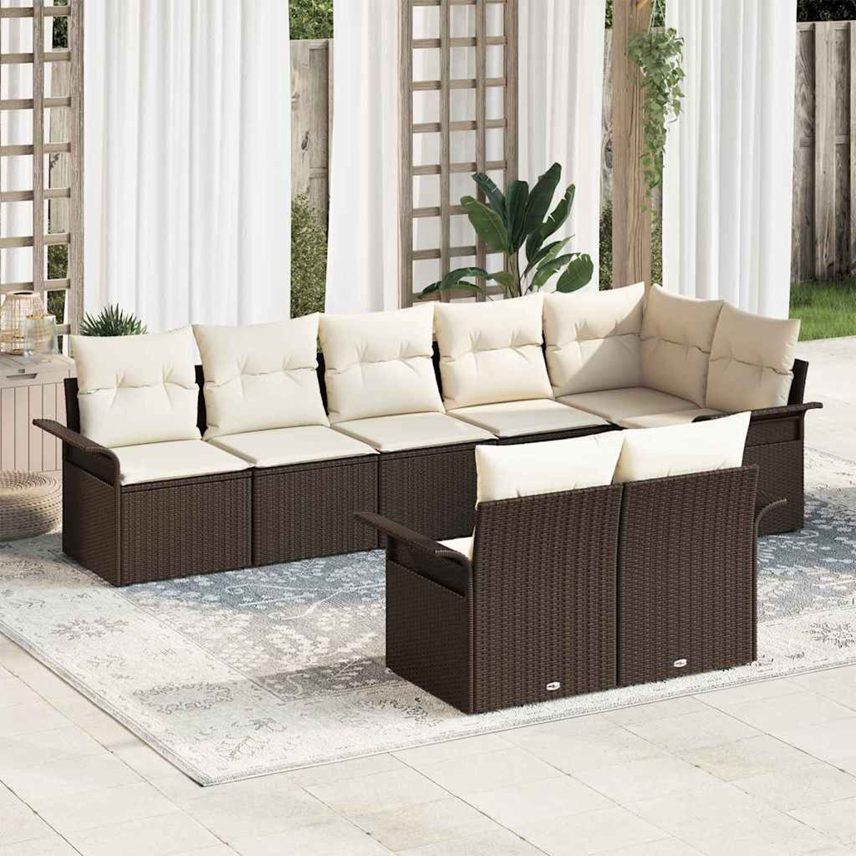 Outdoor-Ecksofa mit cremefarbenen Kissen. Das Sofa steht auf einem gemusterten Teppich. Weiße Vorhänge sind im Hintergrund.