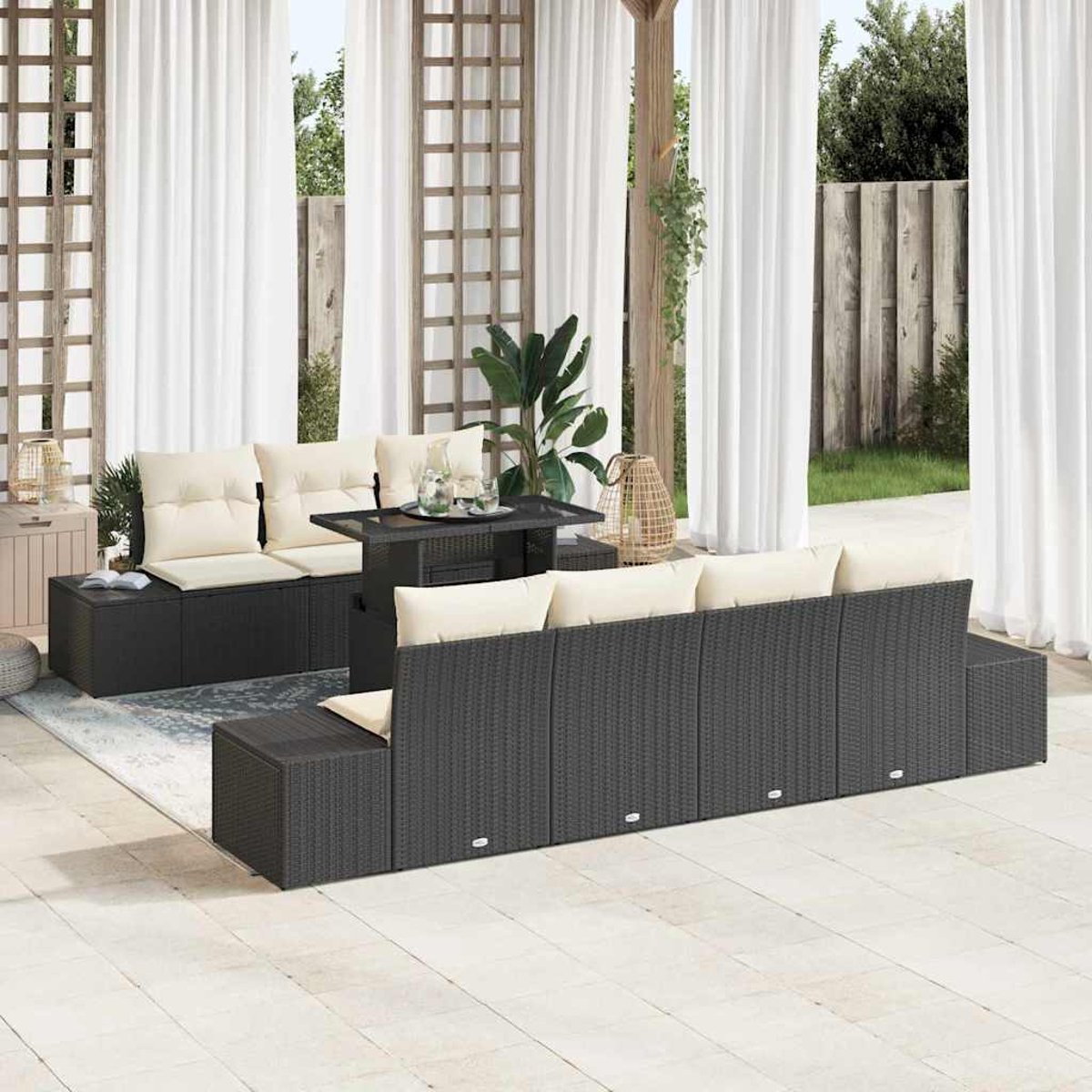 Gartenmöbel-Set mit schwarzem Korbmöbeln, beigen Kissen und einem Tisch, vor weißen Vorhängen und einem Garten.